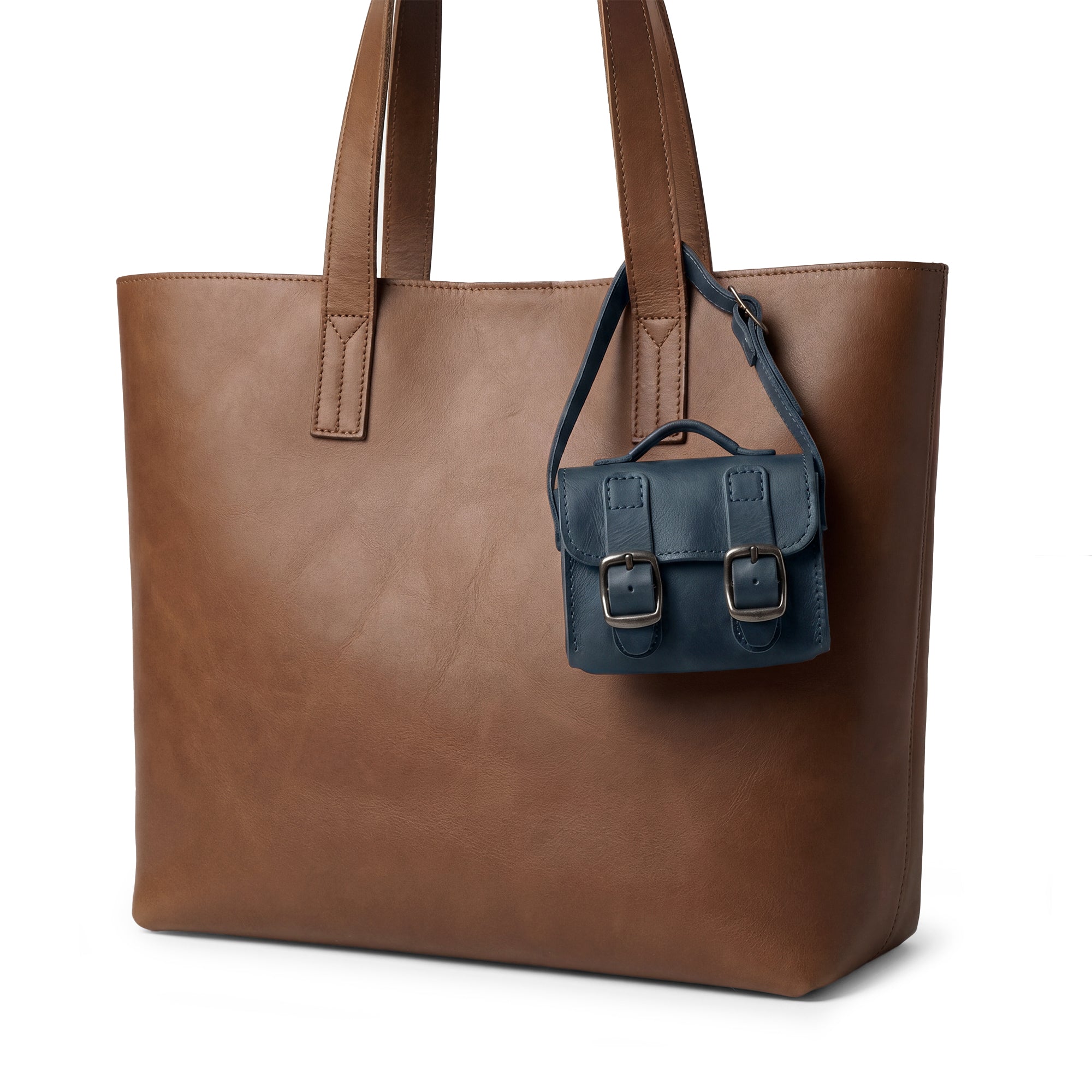 The deep blue Tiny Messenger Bag by Hide & Drink, a unique Mini Messenger Bag Charm crafted from rich Full Grain Leather. This artisanal piece is perfect as a keychain or handbag accent, showcasing meticulous handmade quality from La Antigua Guatemala.