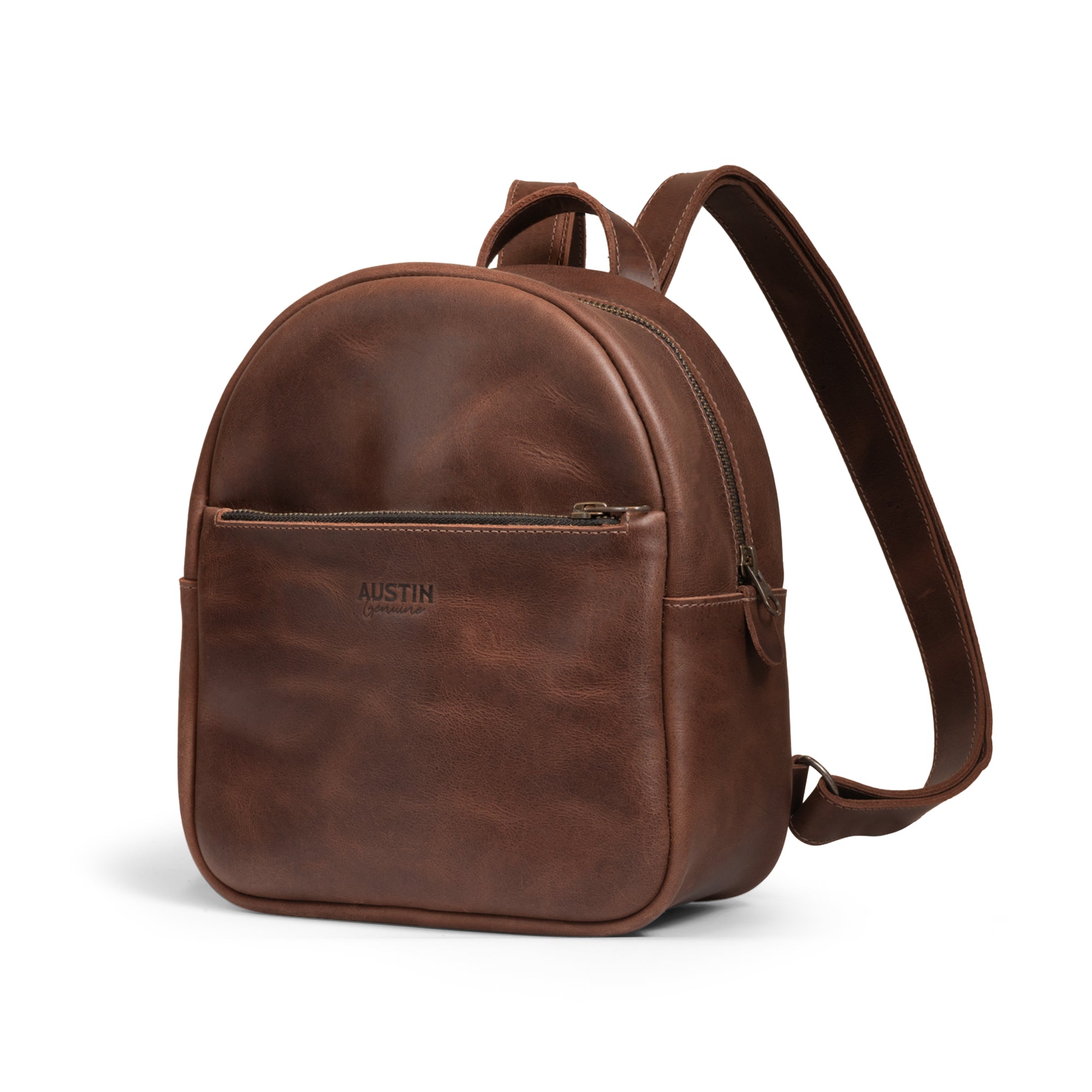 A side view of The Holly Mini Backpack by Austin Genuine, showcasing its rich, full grain leather finish and artisan craftsmanship with tags like Full Grain Leather, StockyardX, Small Batch Production, Hand Cut, Hand Sewn, Fire Branded, Handmade in La Antigua Guatemala & Oaxaca Mexico.