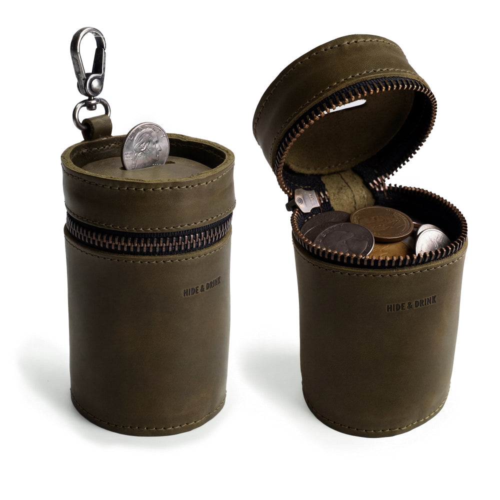 Stylish Bucket Coin Release by Hide & Drink, showcasing a full grain leather piggy bank bucket style with a zipper and attached clip, ideal as a money box or cash organizer. This artisan handmade coin case is crafted in La Antigua Guatemala & Oaxaca Mexico.