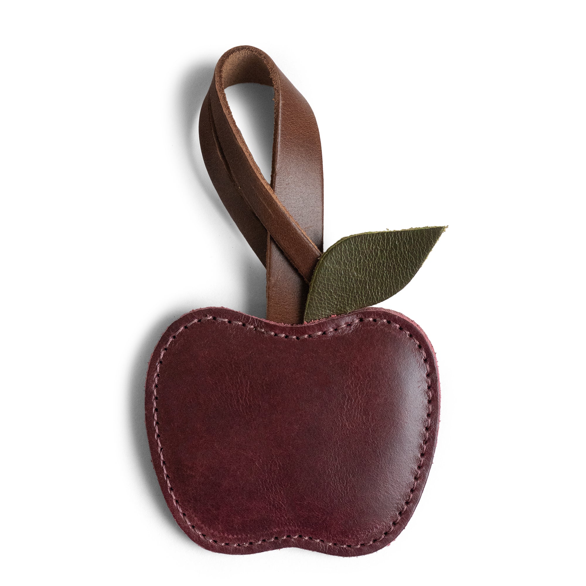 Hide & Drink Apple Bag Charm featuring a leather apple design, perfect as a purse charm for handbags, totes, and backpacks. Handcrafted from full grain leather, this artisan piece reflects small batch production, fire-branded details, and handmade craftsmanship from La Antigua Guatemala and Oaxaca Mexico.