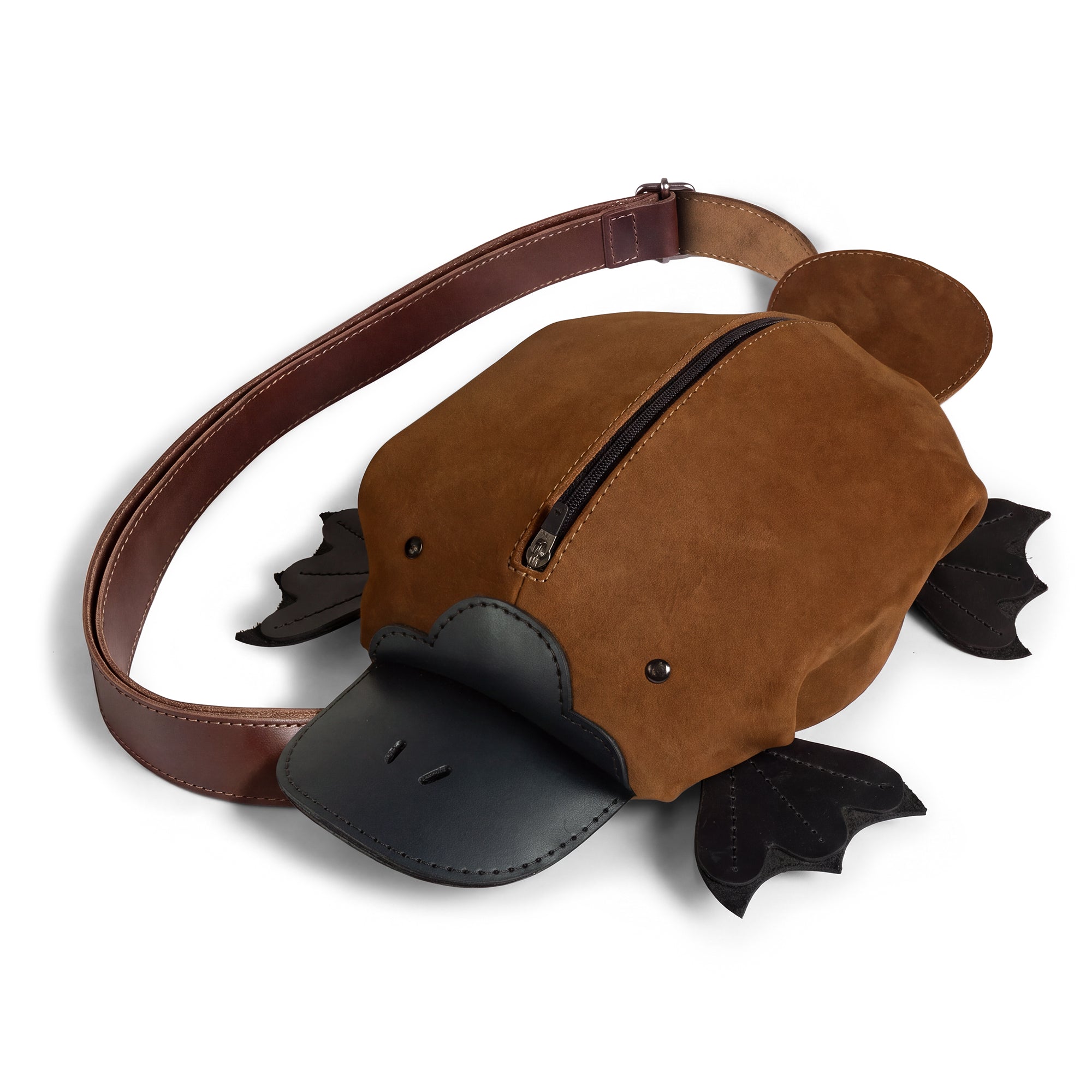 Tudi Frudi Platypurse Crossbody Bag in brown Swayze Suede and Full Grain Leather, shown as a playful platypus-shaped Messenger Bag with Adjustable Shoulder Strap, Zippered Sling Bags styling, Travel Backpack versatility, Purses for Men and Women appeal, Satchel-inspired design, StockyardX Small Batch Production, Hand Cut and Hand Sewn Artisan craftsmanship, Fire Branded detail, Handmade in La Antigua Guatemala & Oaxaca Mexico.