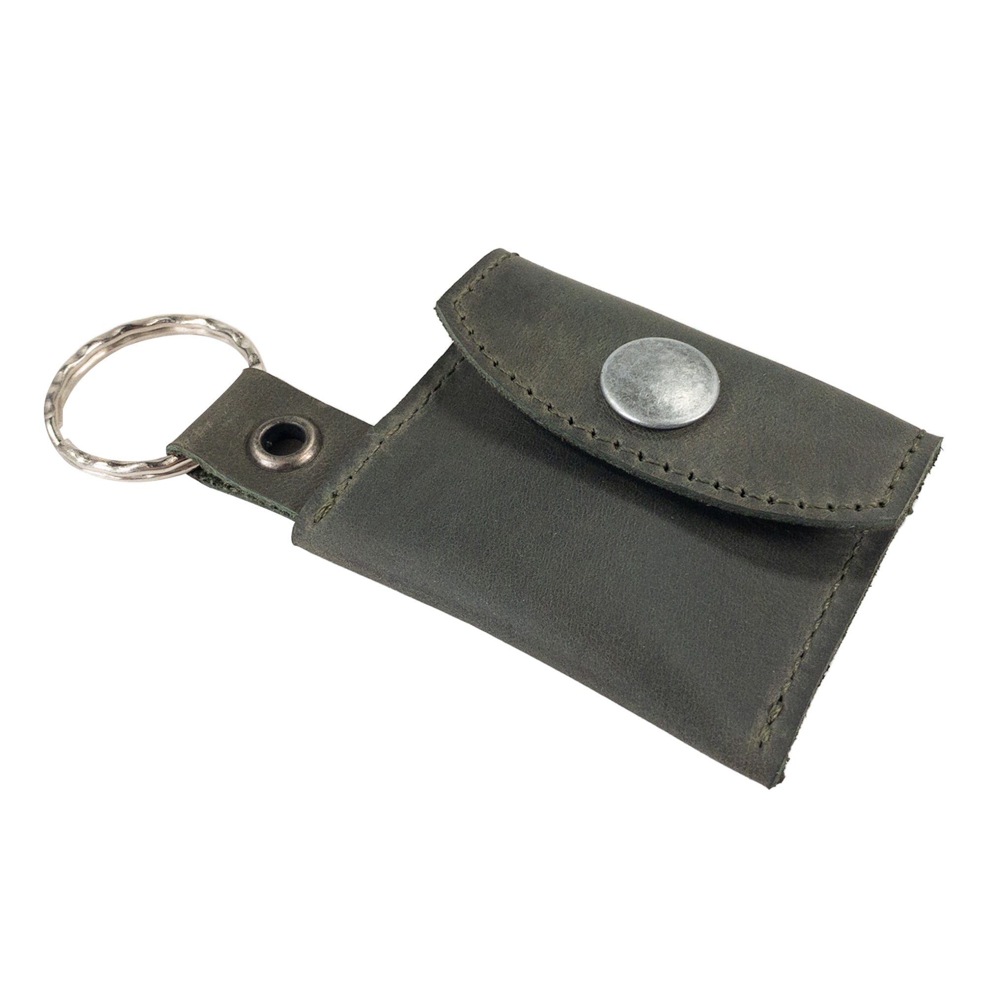 Tiny Coin Holder Keychain by Hide & Drink accompanied by a warranty card showcasing its handmade quality. This Full Grain Leather piece is an example of artisan craftsmanship from small batch production.