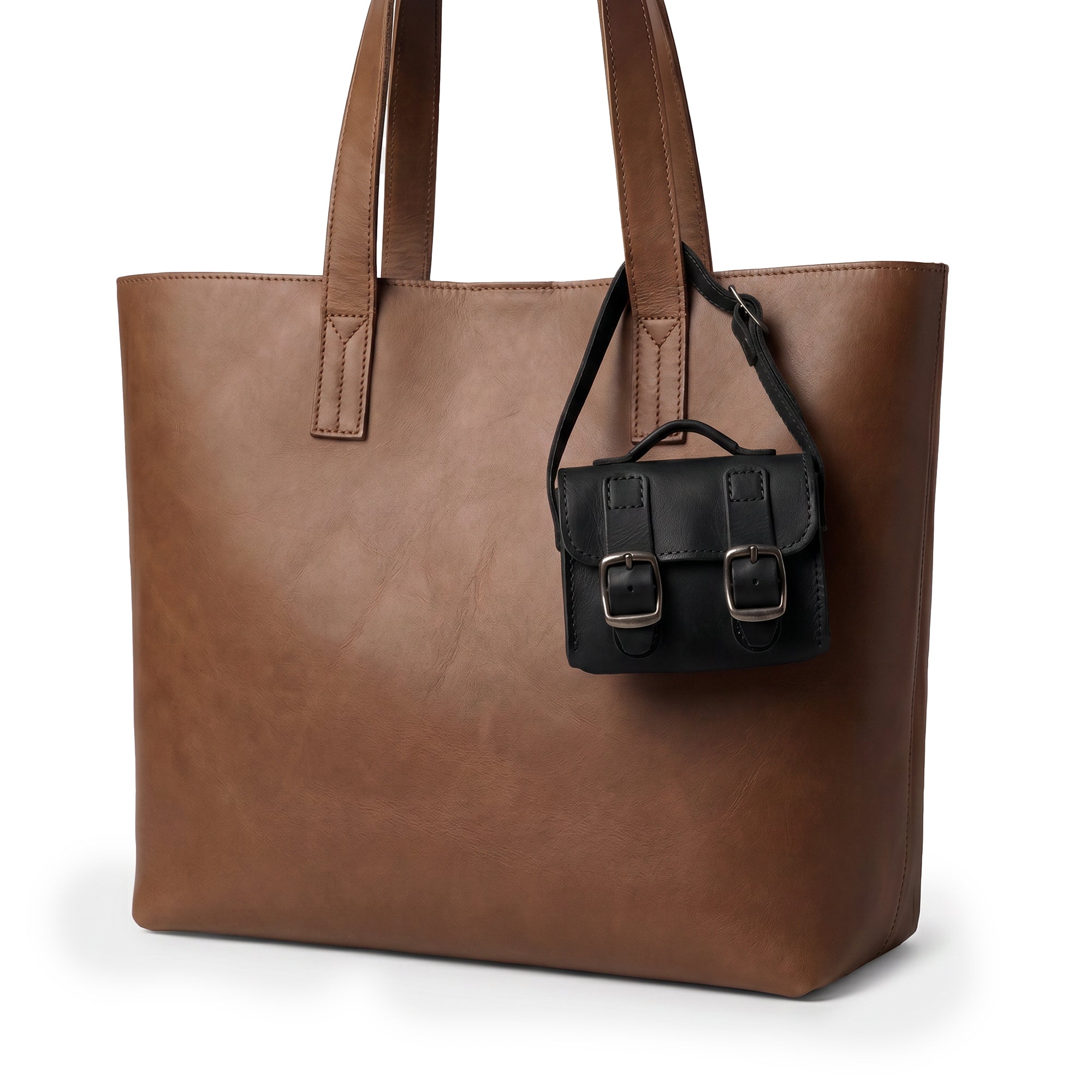 Front view of the Black Tiny Messenger Bag by Hide & Drink, a distinguished Mini Messenger Bag Charm crafted from rich Full Grain Leather. This artisan accessory, perfect as a keychain or handbag complement, reflects small batch production made in La Antigua Guatemala.