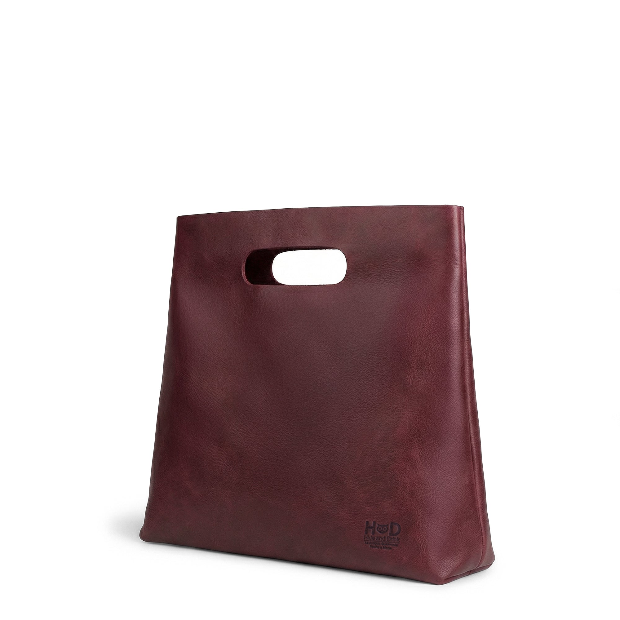 The side profile of the red Minimalist Boho Handbag by Hide & Drink, showcasing its unique design and structure. This Minimalist Handbag for Women functions as a chic Tote Bag, made from beautiful Full Grain Leather, reflecting StockyardX’s artisan dedication to Small Batch Production, with each piece Handmade in La Antigua Guatemala & Oaxaca Mexico.