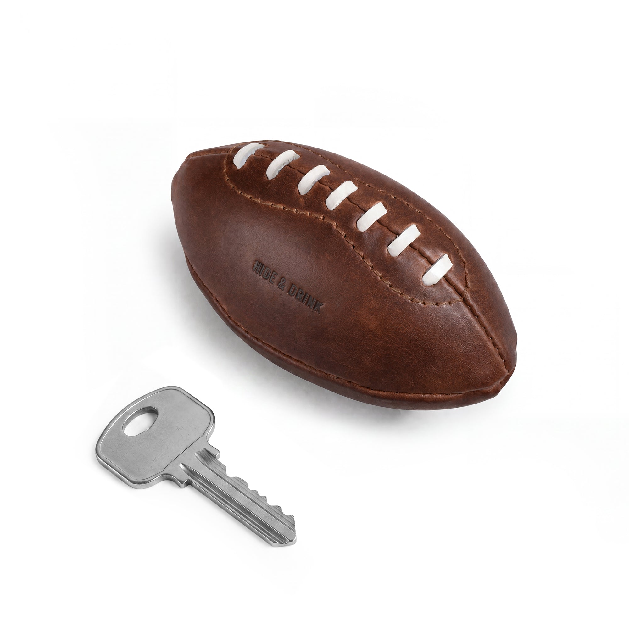 Top view of a Mini American Football by Hide & Drink, crafted from full grain leather with hand-stitched seams. This soft, durable ball serves as a decoration or keepsake, showcasing artisan craftsmanship from Small Batch Production, made in La Antigua Guatemala & Oaxaca Mexico.