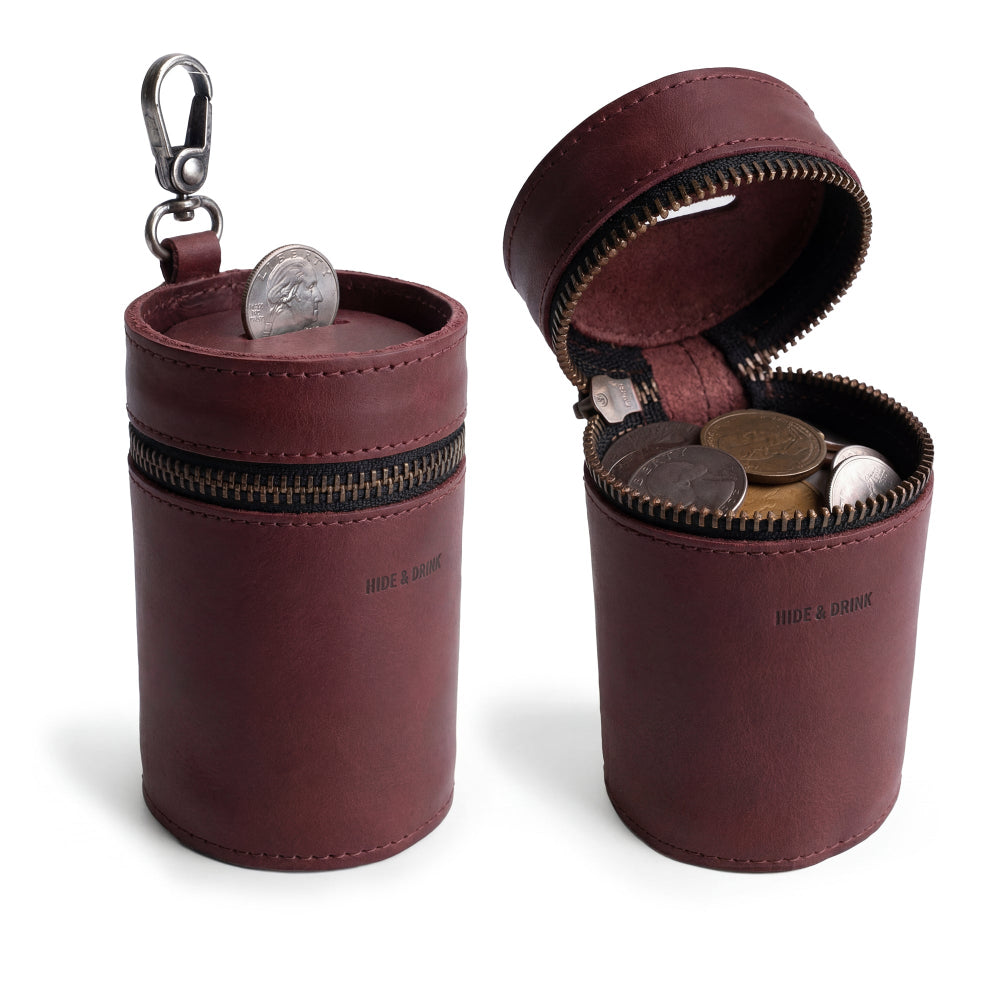 The Bucket Coin Release by Hide & Drink, a stylish piggy bank bucket crafted from full grain leather, serves as a versatile cash organizer. This zippered pouch securely holds coins while showcasing artisan craftsmanship, handmade in La Antigua Guatemala and Oaxaca Mexico.