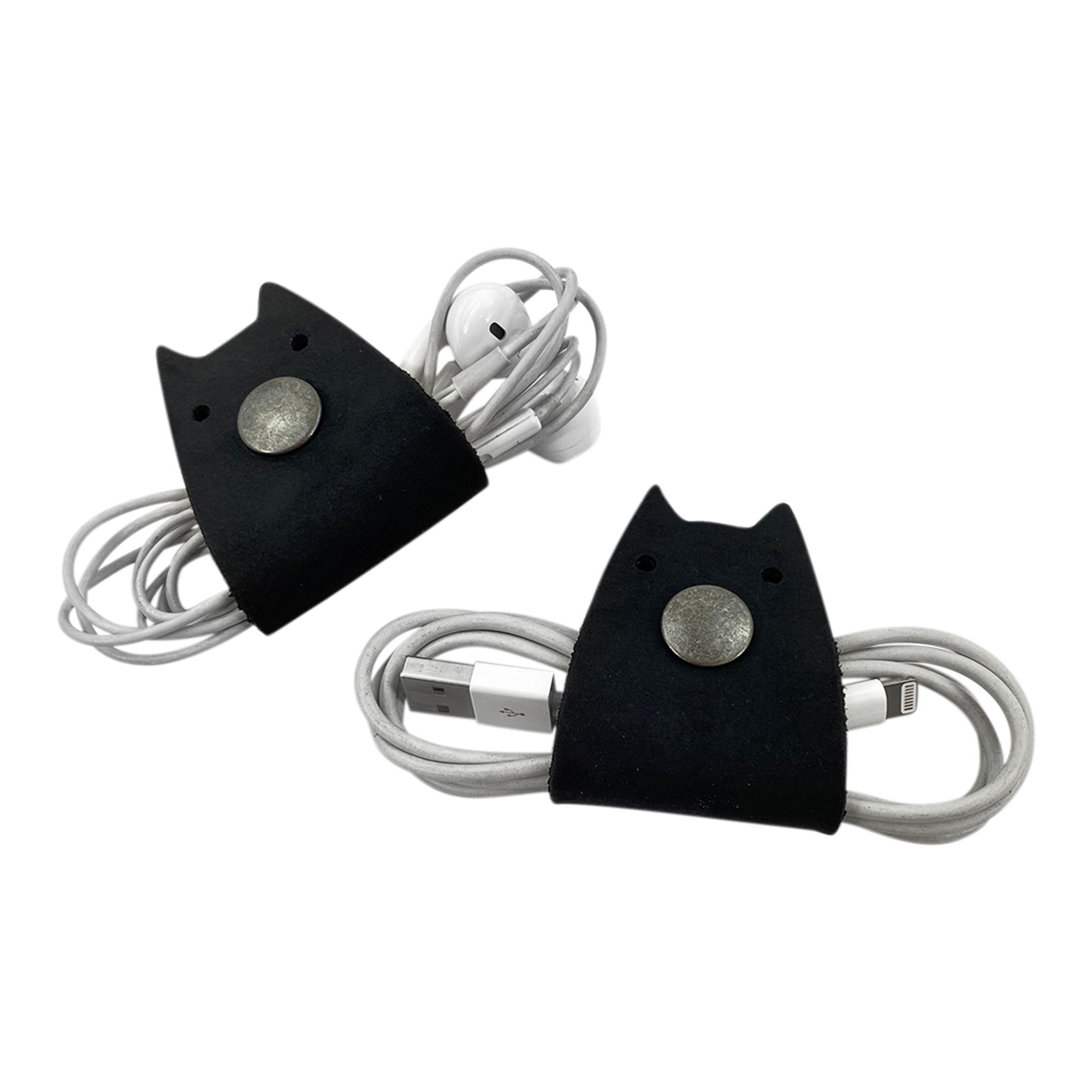 Taco Dog's Cat Cord Keeper (2 Pack) black leather version shown with wrapped cords. These stylish cord keepers help you manage earbuds, headphones, and chargers easily. Crafted from durable full grain leather and handmade in La Antigua Guatemala & Oaxaca Mexico.