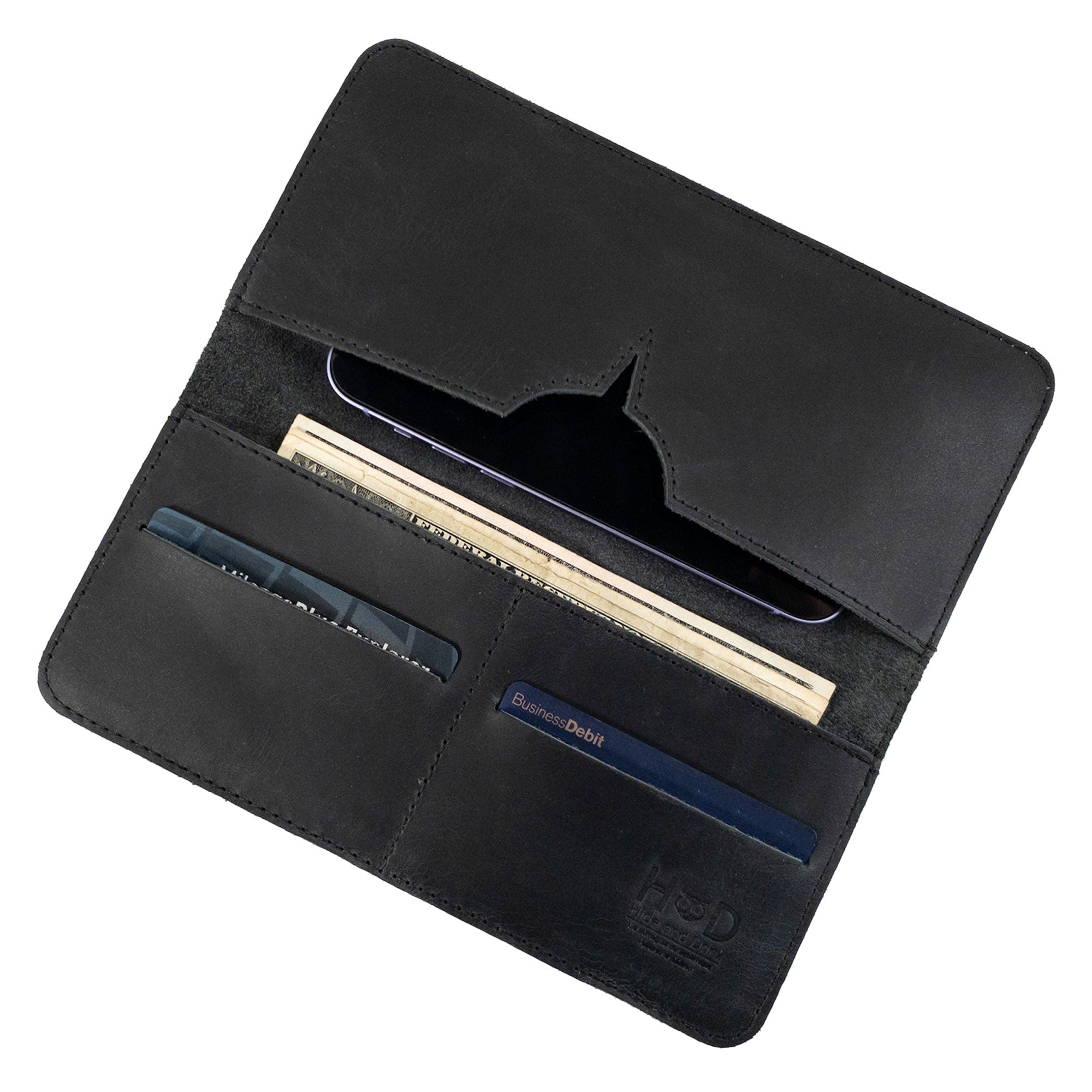 Open black bifold wallet for cellphone by Hide & Drink, displaying card slots and cash compartment. This Bifold Wallet for Cellphone pairs premium Full Grain Leather with ideal organization features. Handcrafted with care in small batches by artisans in La Antigua Guatemala & Oaxaca Mexico.