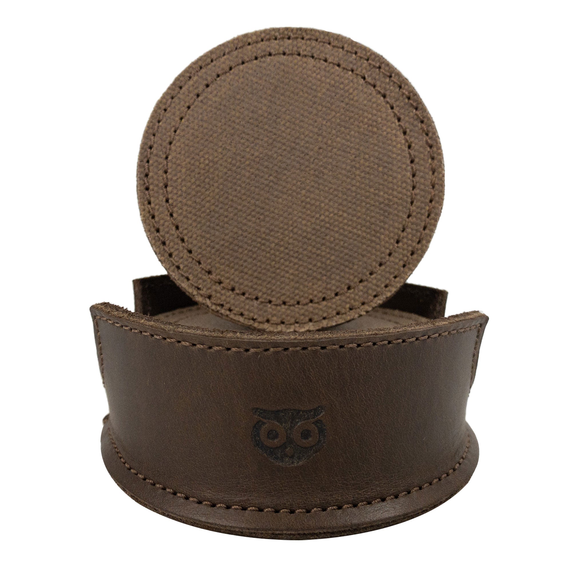 A leather holder with coasters presented in shades of brown from the Set of 8 Circular Coasters for Drinks by Hide & Drink. These coasters are designed for Glass & Cups Stain Protection and made with quality Waxed Canvas and Full Grain Leather. Experience the craftsmanship of StockyardX through these Small Batch Production items that are Hand Cut, Hand Sewn, Fire Branded, and made Artisan, Handmade in La Antigua Guatemala & Oaxaca Mexico.