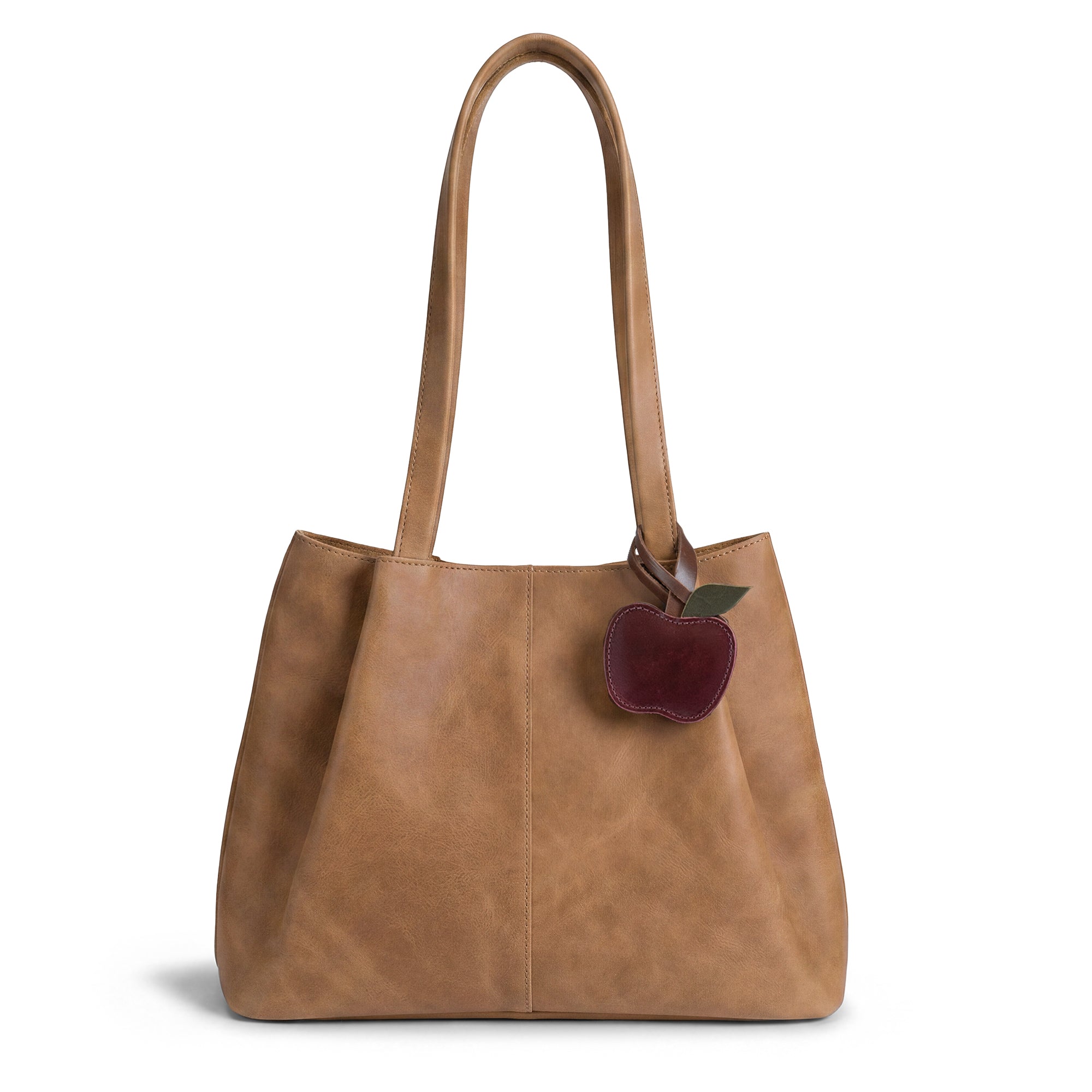 Stylish Hide & Drink Apple Bag Charm attached to a chic leather tote bag, showcasing its unique design as an ornament for women. Made from full grain leather, this small batch product offers a personalized touch, crafted by hand in La Antigua Guatemala and Oaxaca Mexico.