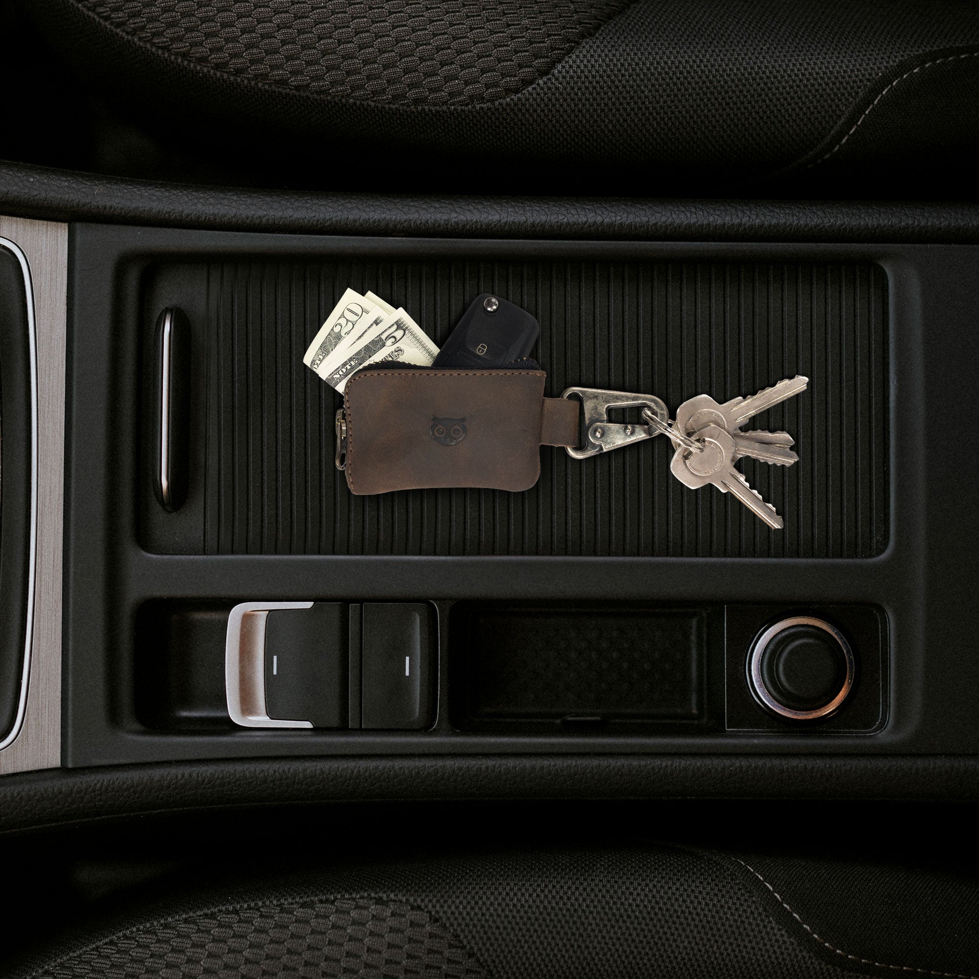 Hide & Drink Car Key Holder placed inside a car's console, demonstrating its functionality in holding keys, cash, and cables. This handmade leather accessory is perfect for keeping essentials organized.