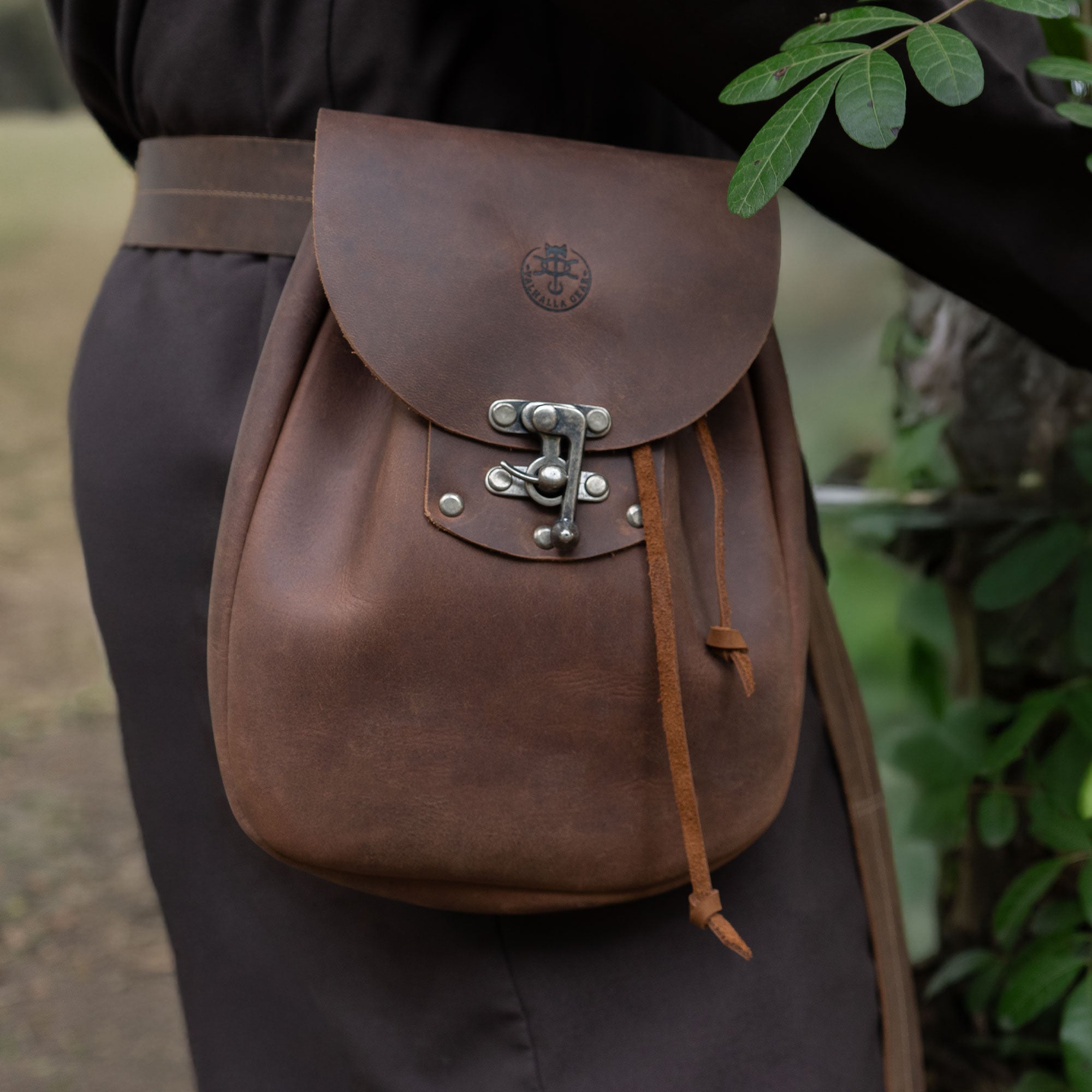 Side view of a user wearing a Full Grain Leather Medieval Style Belt Bag by Valhalla Gear. This Waist Bag complements the outfit while serving as a perfect Camping Pouch for Essentials. Crafted with Artisan methods, it features Small Batch Production, Hand Cut, Hand Sewn, and Fire Branded details, made in La Antigua Guatemala & Oaxaca Mexico.