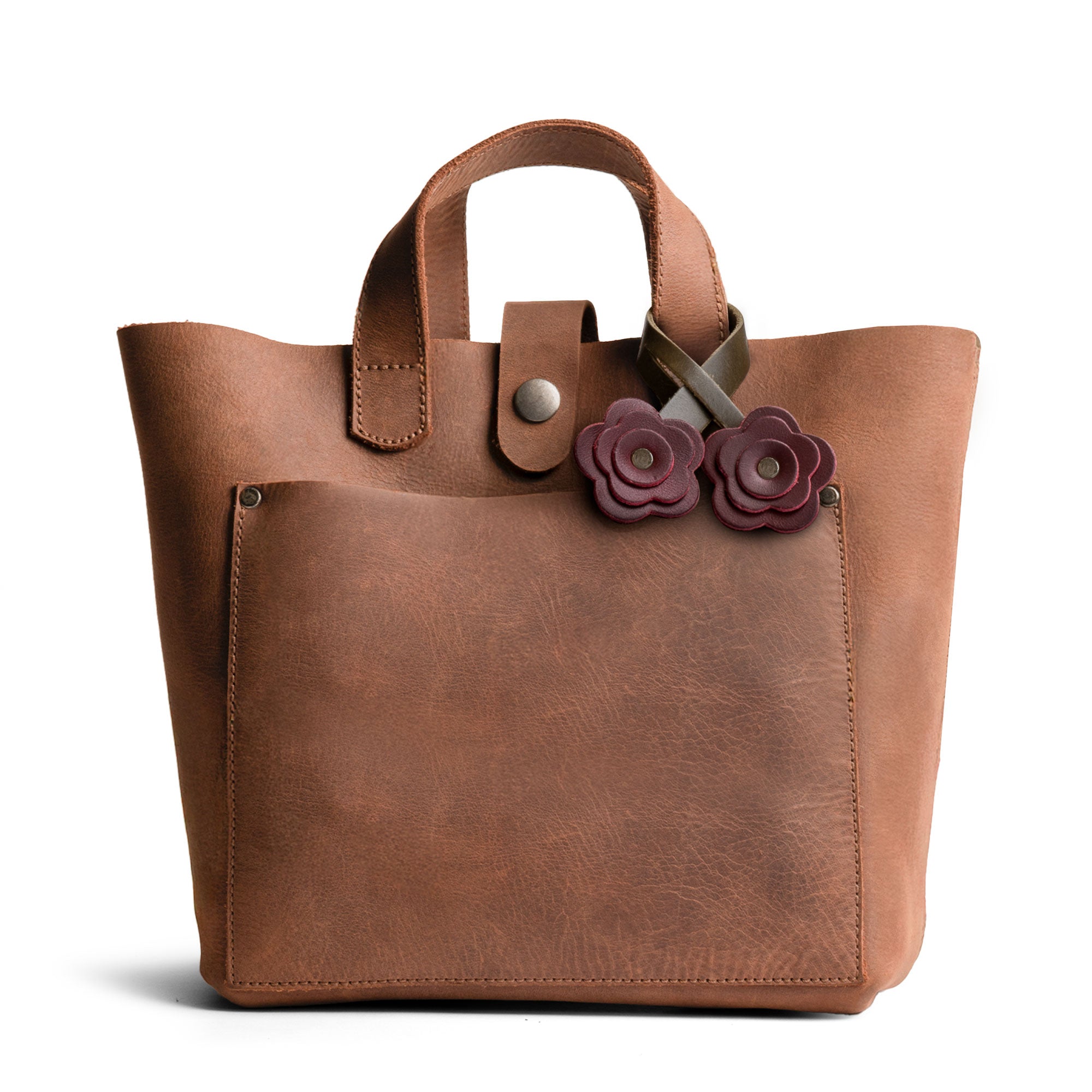 The Rose Bag Ornament by Hide & Drink attached to a stylish tote, illustrating how this Full Grain Leather Rose-Shaped Ornament serves as a delightful charm, enhancing your bag's appeal.
