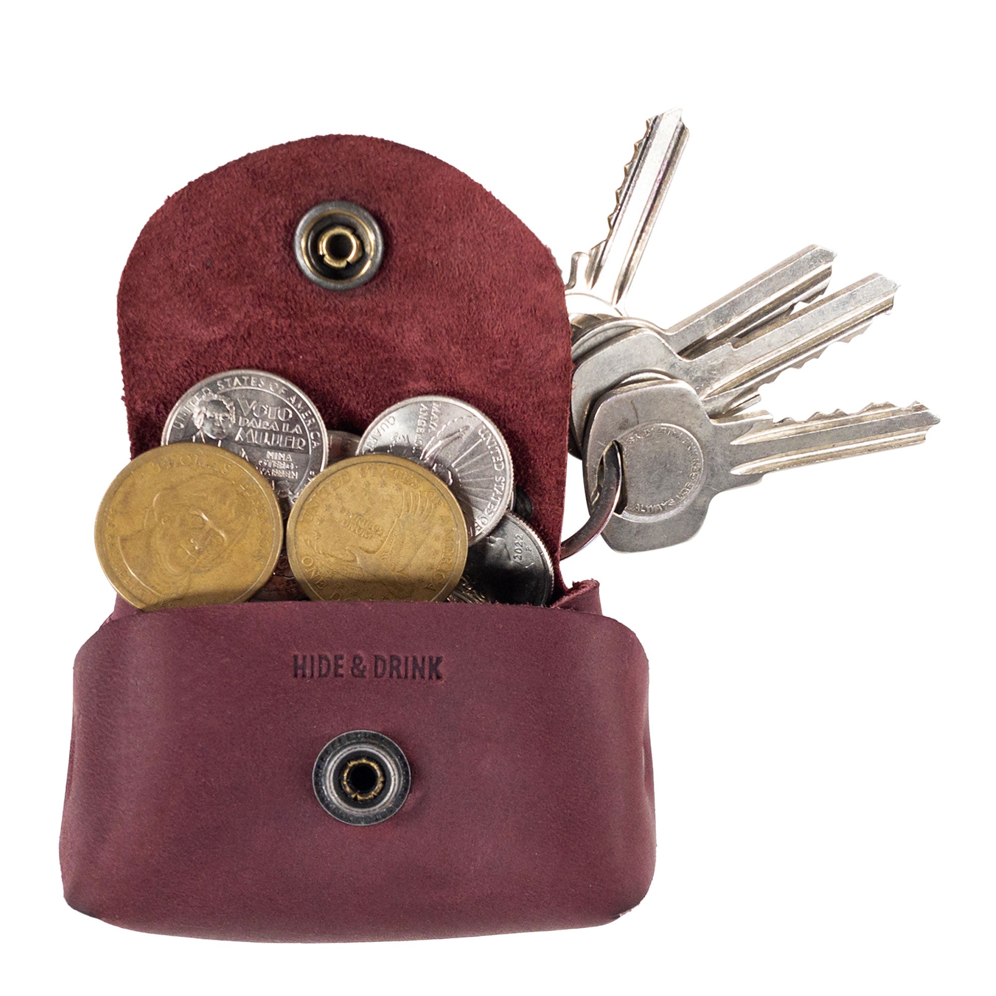 Inside view of the Tiny Handbag Keychain by Hide & Drink, filled with coins and keys, demonstrating the functional layout. This unique keychain in Full Grain Leather represents artisan quality through small batch production and meticulous hand cut and hand sewn techniques.