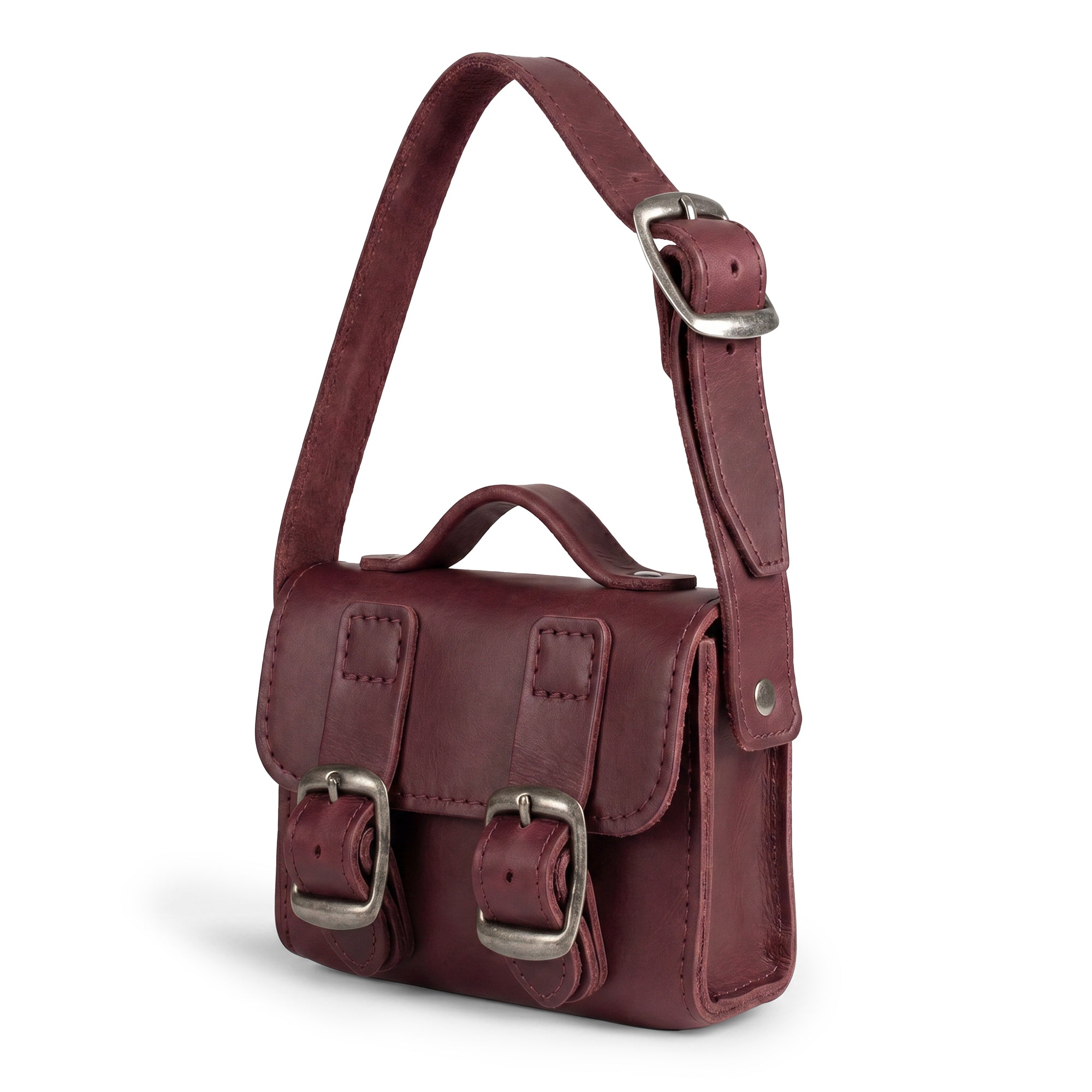 Side view of the burgundy Tiny Messenger Bag by Hide & Drink, highlighting its premium Full Grain Leather texture. This charming Mini Messenger Bag Charm is a stylish addition to any handbag or keychain, reflecting artisan craftsmanship in La Antigua Guatemala.