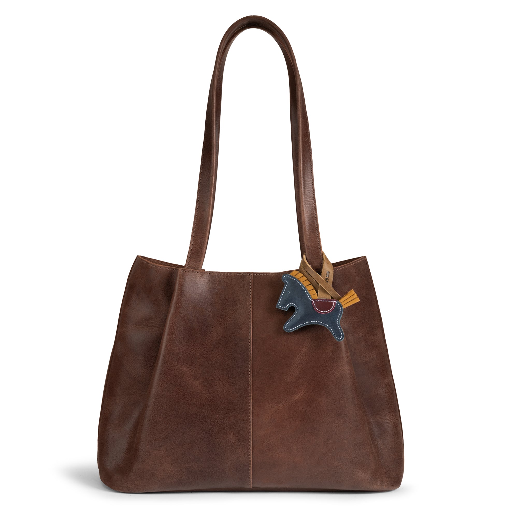Stylish Hide & Drink Horse Bag Charm attached to a leather handbag, showcasing its unique design. This full grain leather charm is a perfect ornament for women’s fashion. Handmade in La Antigua Guatemala, it embodies artisan craftsmanship in small batch production, ideal for totes and backpacks.
