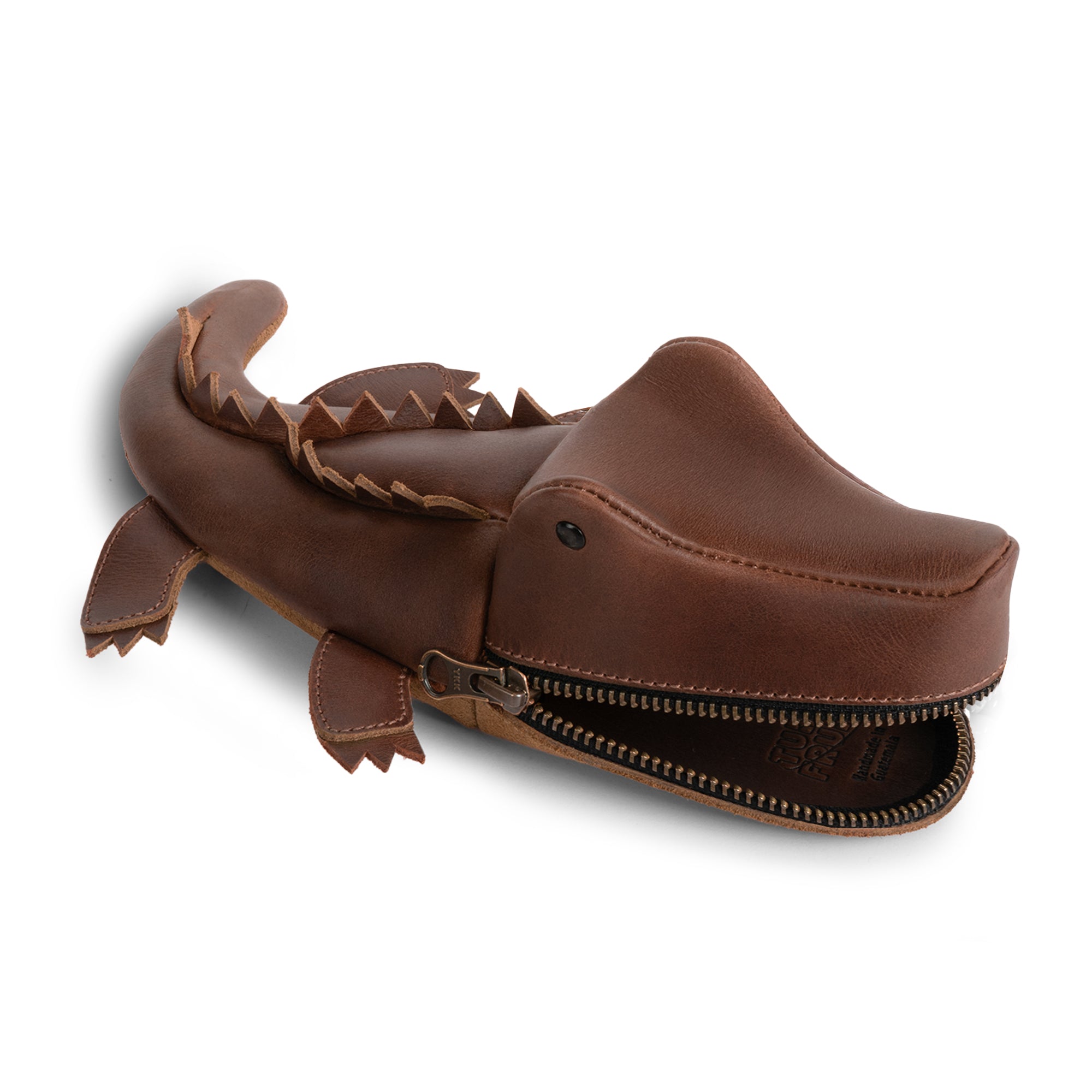 Close-up of the Leather Gator Pouch by Tudi Frudi, displaying its charming crocodile design. This Gator Leather Pouch can function as an alligator-shaped coin purse, small charger cable holder, or even a change bag. The premium full grain leather is hand cut and sewn, reflecting small batch production and artisan quality. Perfect as a stylish scissors case or travel zippered bag, this exquisite piece is handcrafted in La Antigua Guatemala & Oaxaca, Mexico.