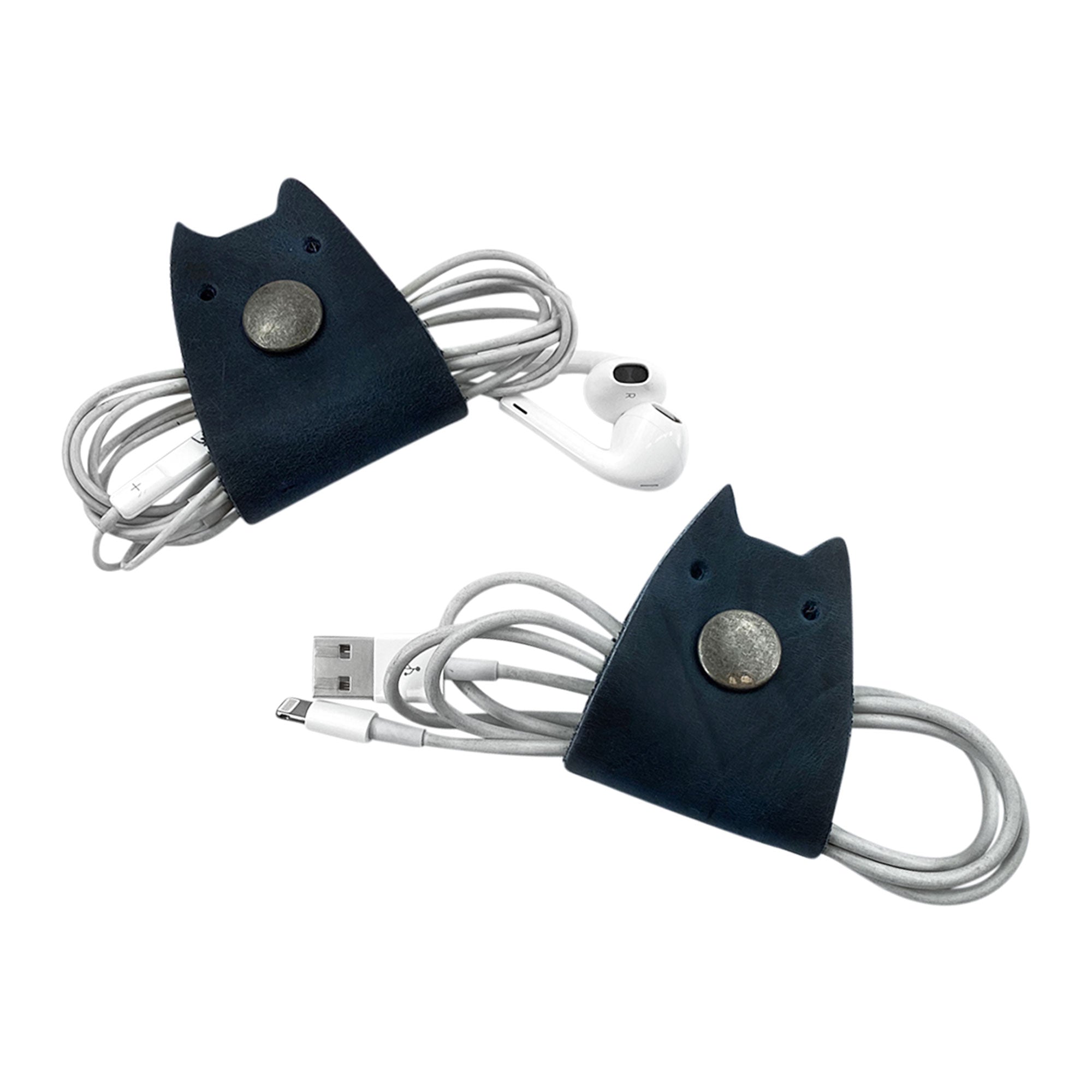 Navy Taco Dog Cat Cord Keeper (2 Pack) displayed with cords wrapped up smartly. Stylish full grain leather helps manage your cables, earbuds, and chargers effortlessly in travel situations. Artisan crafted in La Antigua Guatemala & Oaxaca Mexico.