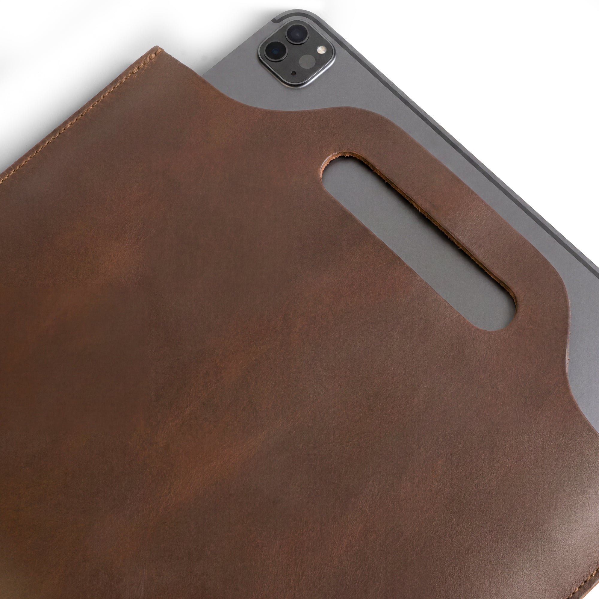 Flat Handbag by Hide & Drink displayed with documents and pens, emphasizing its functionality as a thin portfolio and classic document holder. Made from full grain leather, this minimalist style carry-on bag is a stylish travel accessory. Each bag is meticulously hand cut, hand sewn, and fire branded, showcasing artisan craftsmanship from La Antigua Guatemala & Oaxaca Mexico.