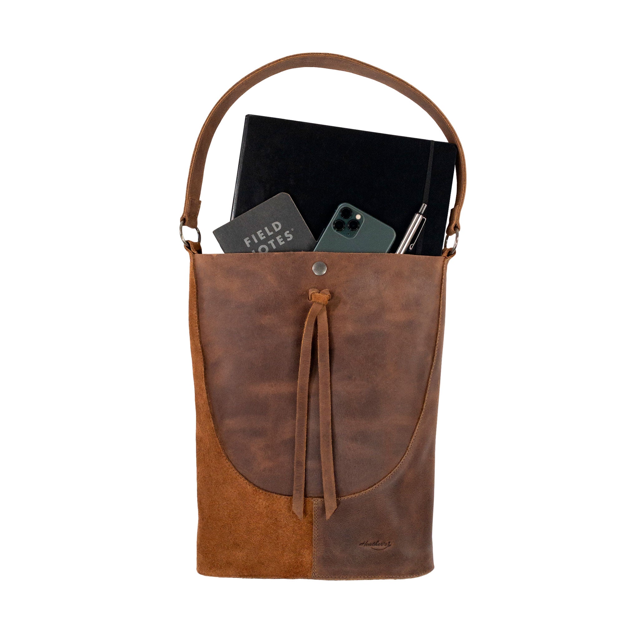 The interior of Heather's Reversed Shoulder Bag filled with essentials, emphasizing its spacious design. This rustic tote bag for women exemplifies a vintage purse style with a shoulder bag strap, made of full grain leather and created through artisan craftsmanship in La Antigua Guatemala & Oaxaca Mexico.