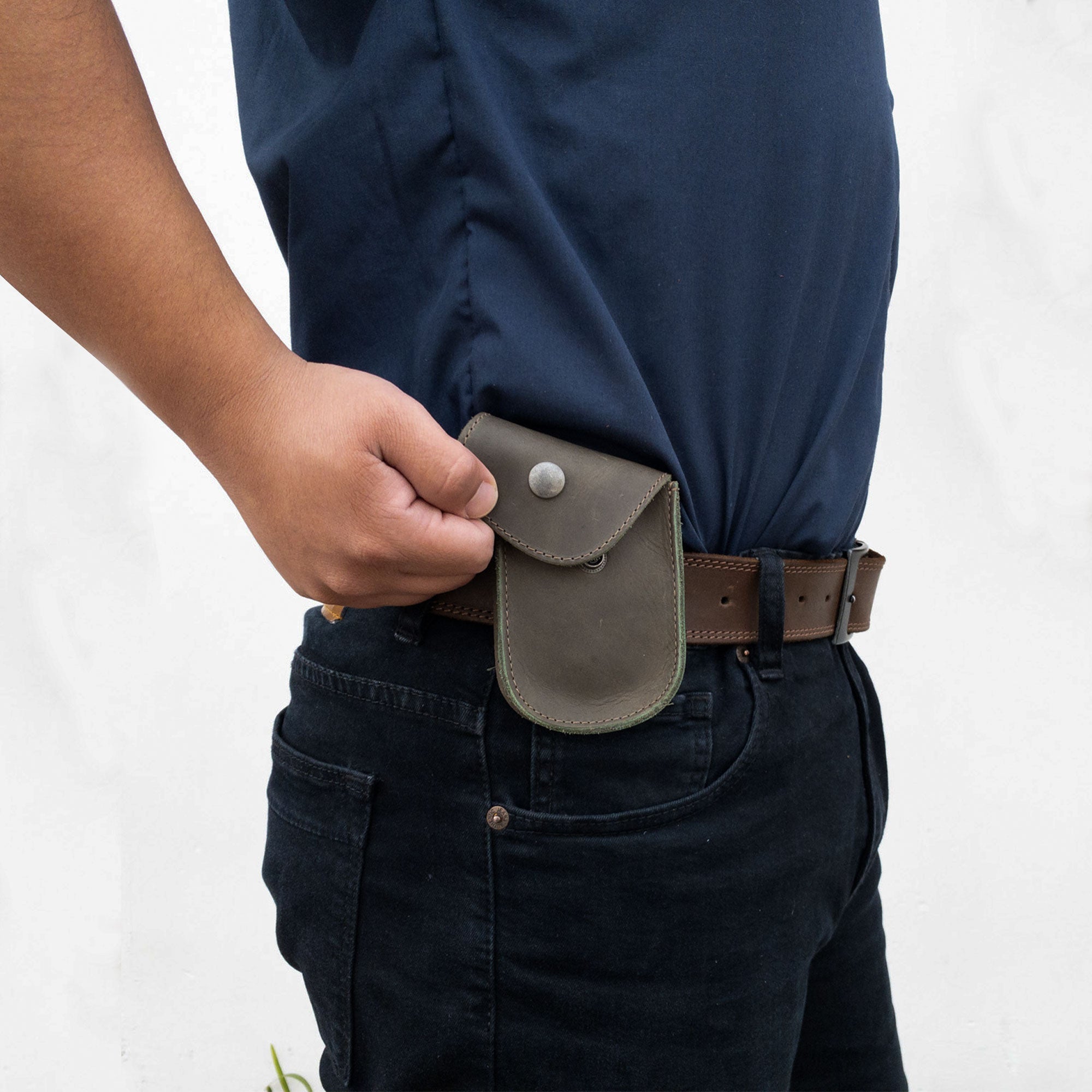 Holster Pouch by Hide & Drink shown attached to a belt, showcasing its practical design and artisan craftsmanship. Perfect for coins and personal items, this durable pouch is made from full grain leather.
