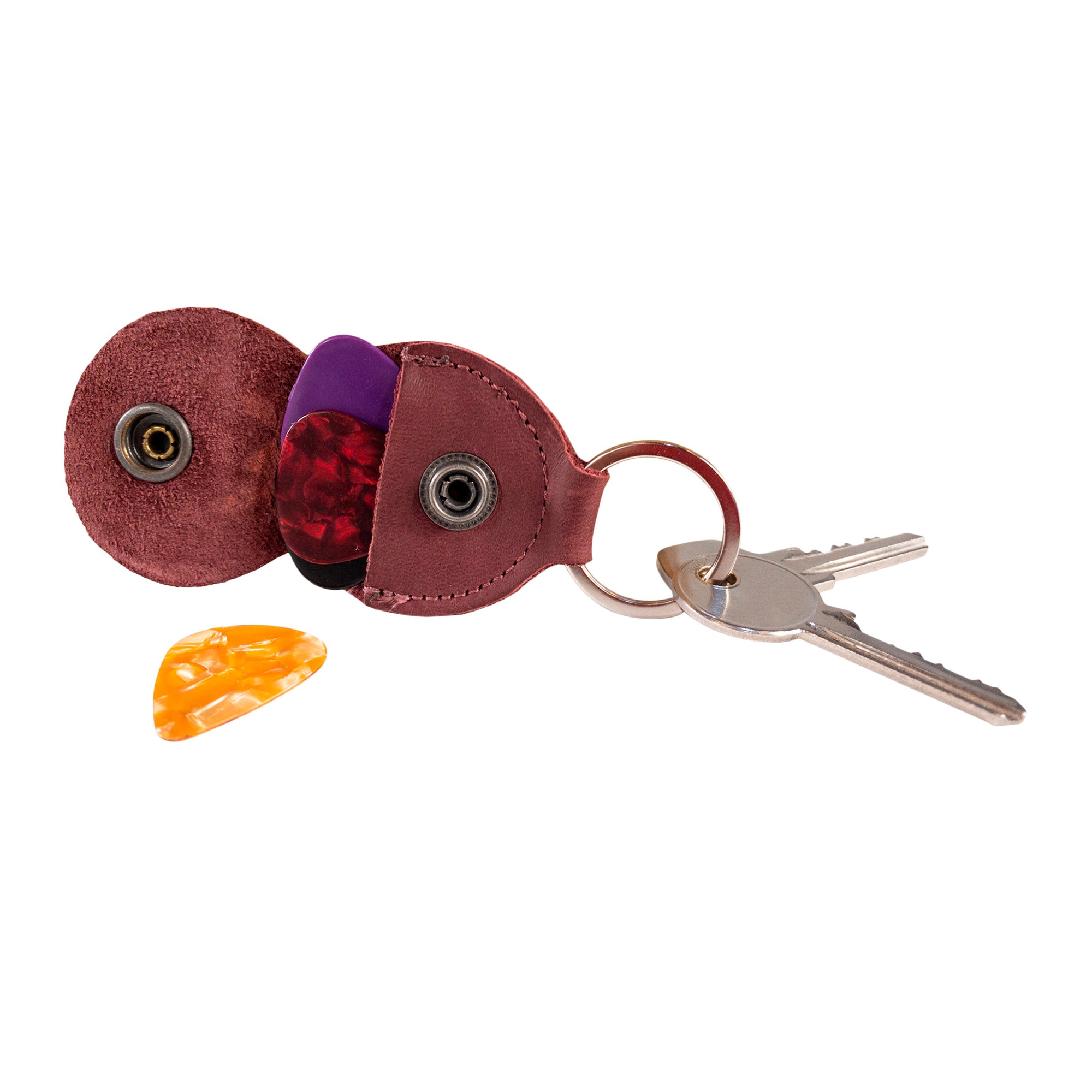 Close-up of the Key Chain & Guitar Pick Holder by Hide & Drink held in hand, emphasizing its compactness. This Guitar Pick Holder with Ring is designed for guitar players as a key organizer, made from premium Full Grain Leather. Showcasing small batch production techniques, each piece is Hand Cut and Hand Sewn with a fire branded emblem, handmade in La Antigua Guatemala & Oaxaca Mexico.