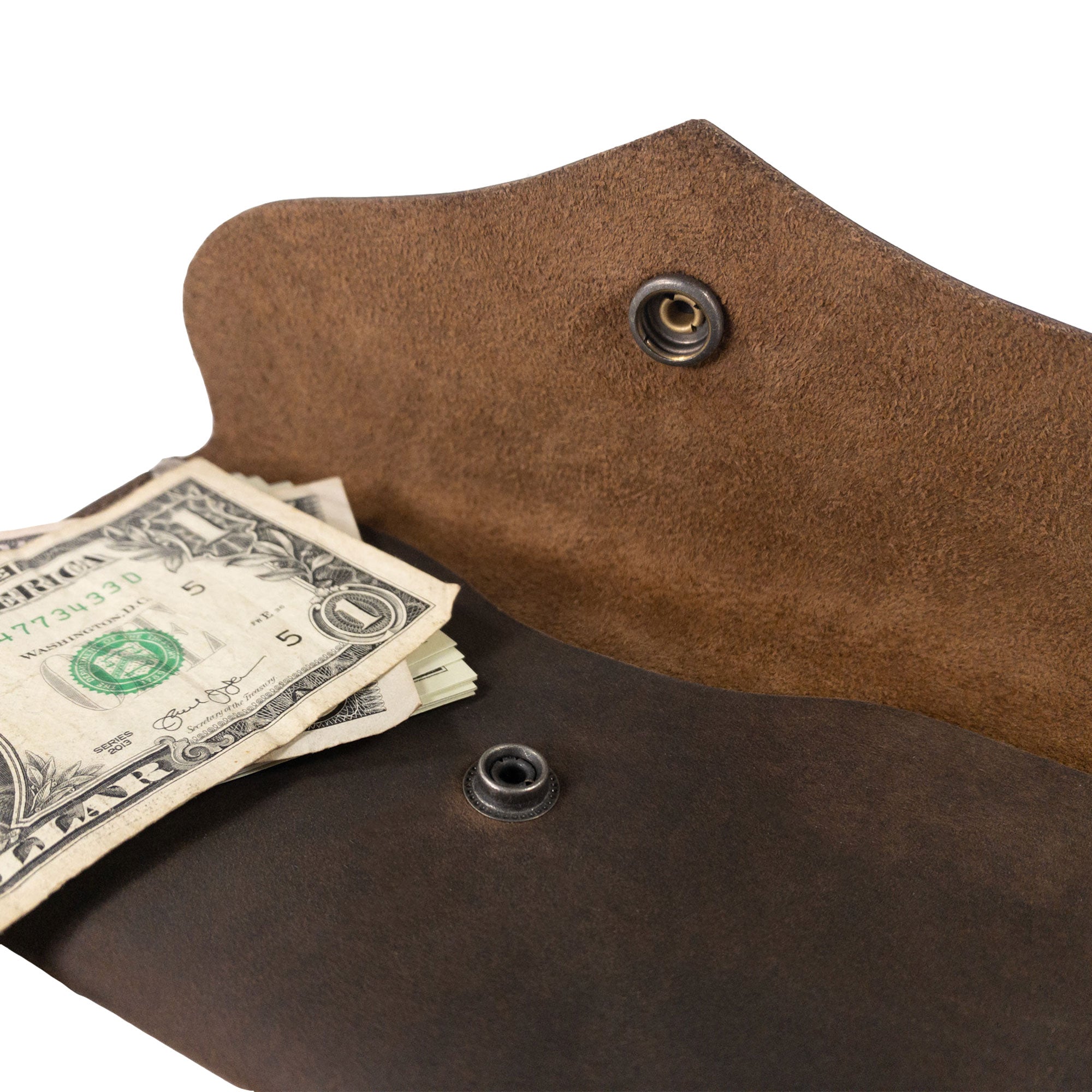 Close-up of the Cash Pouch with Rivets by Hide & Drink highlighting the wallet's button closure and interior with cash. This full grain leather pouch serves as an elegant money organizer. Cash Pouch, Wallet, Money Organizer, Coin Case, Bill Holder, ID Case, StockyardX, Handmade, Full Grain Leather, Small Batch Production, Hand Cut, Hand Sewn, Fire Branded, Artisan, Handmade in La Antigua Guatemala & Oaxaca Mexico.