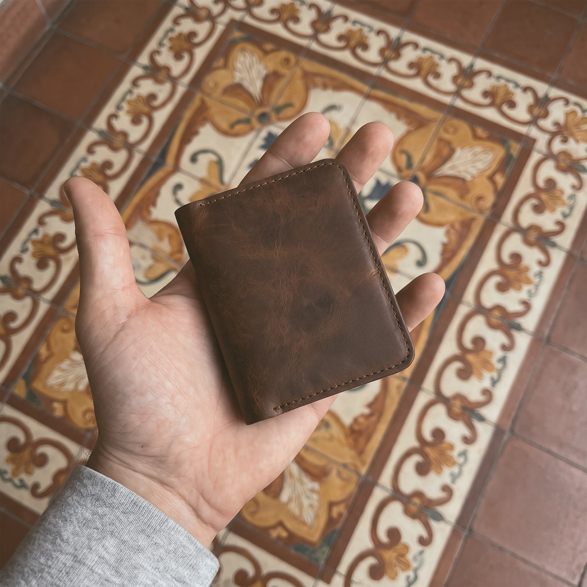 Bi-Fold Card Wallet Diagonal by Hide & Drink with cards inserted, illustrating its capacity to hold up to 5 cards plus folded bills, along with stylish full grain leather craftsmanship, a true accessory for anyone.