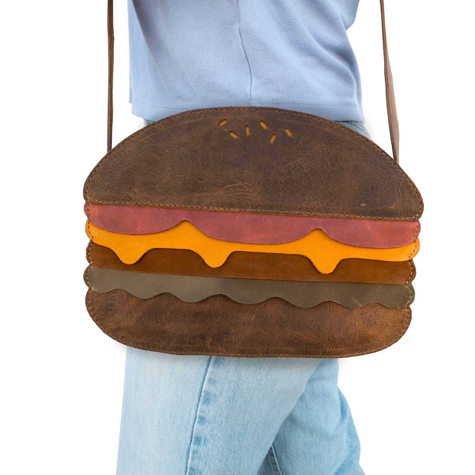 Model displaying the Burger-Shaped Shoulder Bag by Tudi Frudi, adding a playful flair to casual attire. This fashionable Crossbody Bag and Messenger Bag is made from luxurious Full Grain Leather, representing small batch production and artisan craftsmanship. Handmade in La Antigua Guatemala & Oaxaca Mexico, it’s the perfect Travel Accessory for unique style.