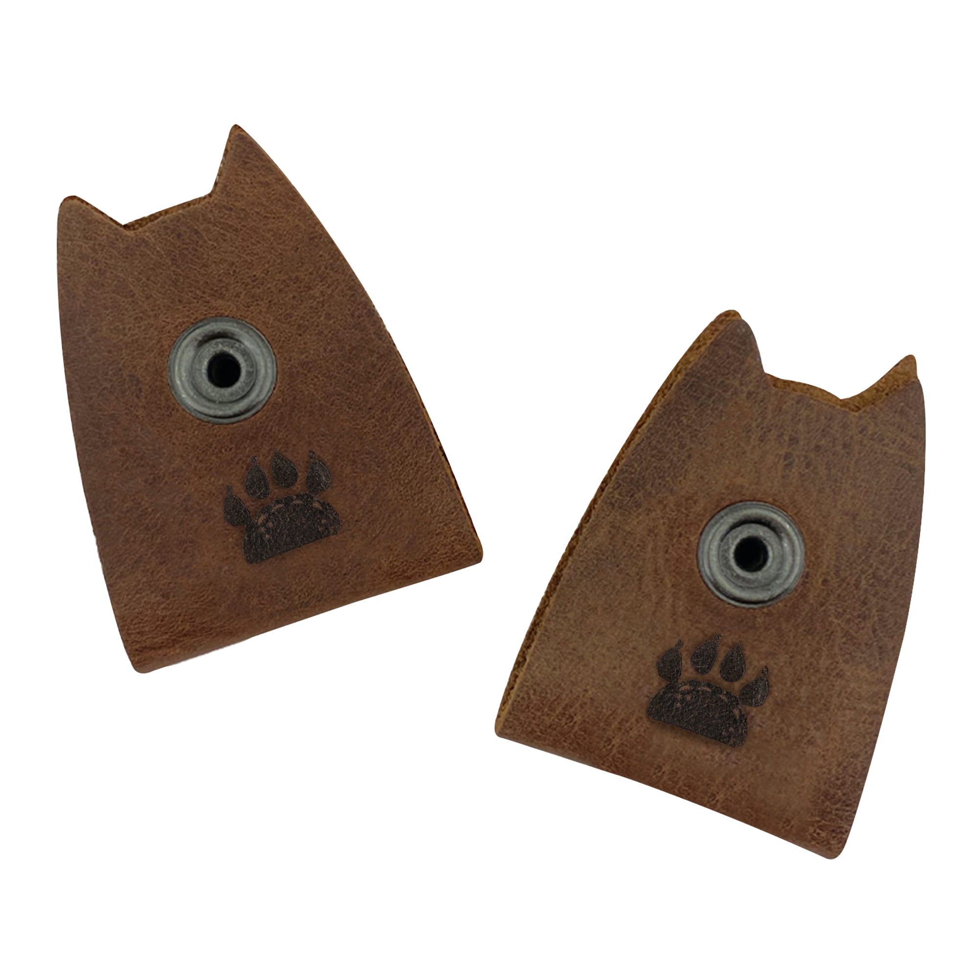 Taco Dog's Cat Cord Keeper (2 Pack) featuring a paw print design. Ideal for managing your cables, earbuds, headphones, and chargers, this full grain leather accessory is both functional and adorable. Clip the snaps for easy organization while traveling. Artisan crafted in La Antigua Guatemala & Oaxaca Mexico.