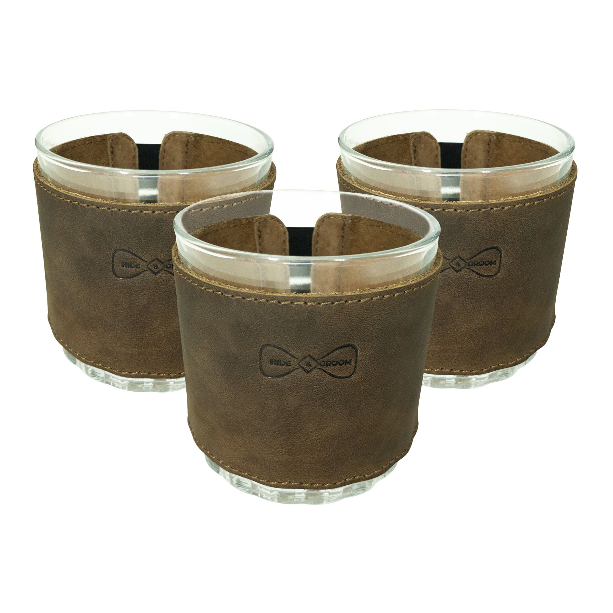 Close-up of the Set of 3 Drinking Glass Covers for Groomsmen by Hide & Groom, showcasing their full grain leather construction. Perfect for wedding ceremonies, these artisan-crafted covers are designed for groomsmen and best men, made using hand cut, hand sewn techniques with a fire branded finish in La Antigua Guatemala & Oaxaca Mexico.