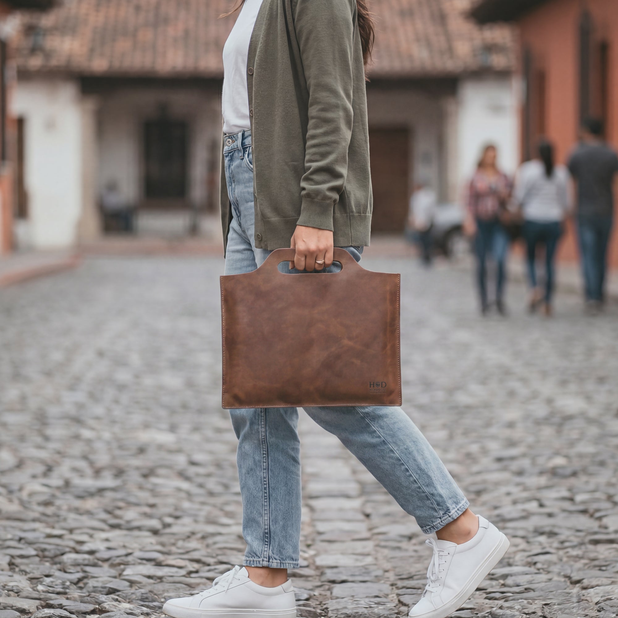 Flat Handbag by Hide & Drink featuring a smooth surface in dark brown full grain leather, ideal for a minimalist style carry-on bag or classic document holder. This thin portfolio showcases the beauty of small batch production, with each piece hand cut, hand sewn, and fire branded. Proudly handmade in La Antigua Guatemala & Oaxaca Mexico, it's a perfect travel accessory.