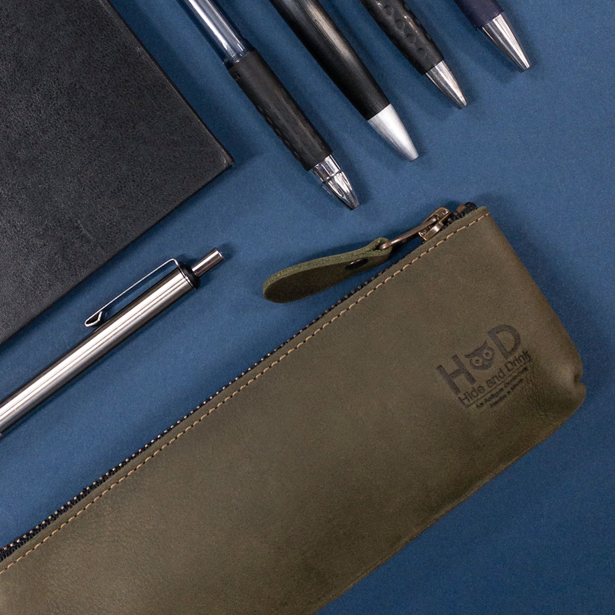 Hide & Drink Pencil Pouch on display, showcasing its elegant functionality as a flat zippered holder for pens and markers. This stylish, rectangular pencil case is made from durable full grain leather and reflects handcrafted quality in La Antigua Guatemala & Oaxaca Mexico, making it a perfect gift for any occasion.