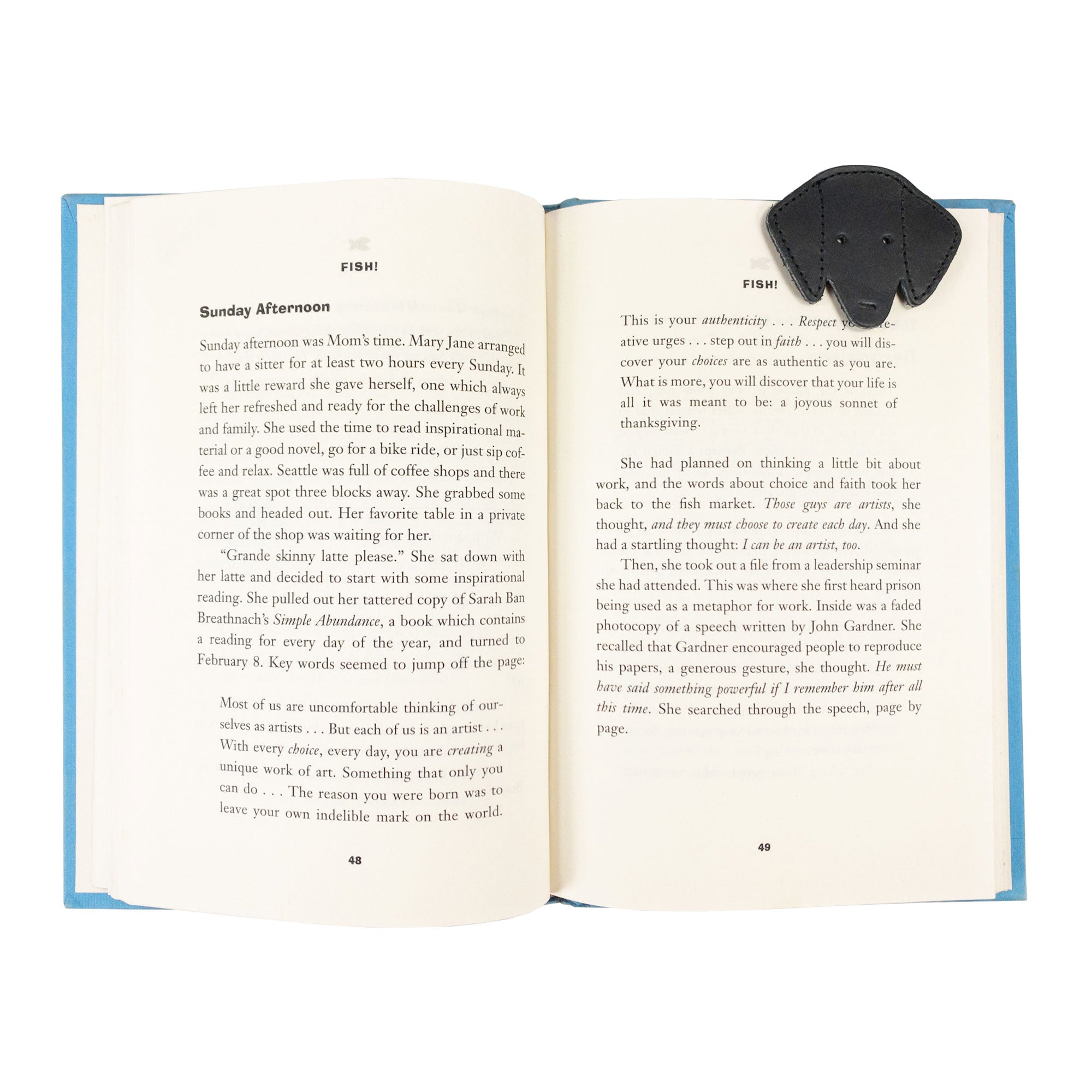 Hide & Drink's black Dog Bookmark in use, enhancing the reading experience with its Full Grain Leather composition. This artisan piece highlights small batch production and fire branding, crafted in La Antigua Guatemala & Oaxaca Mexico.