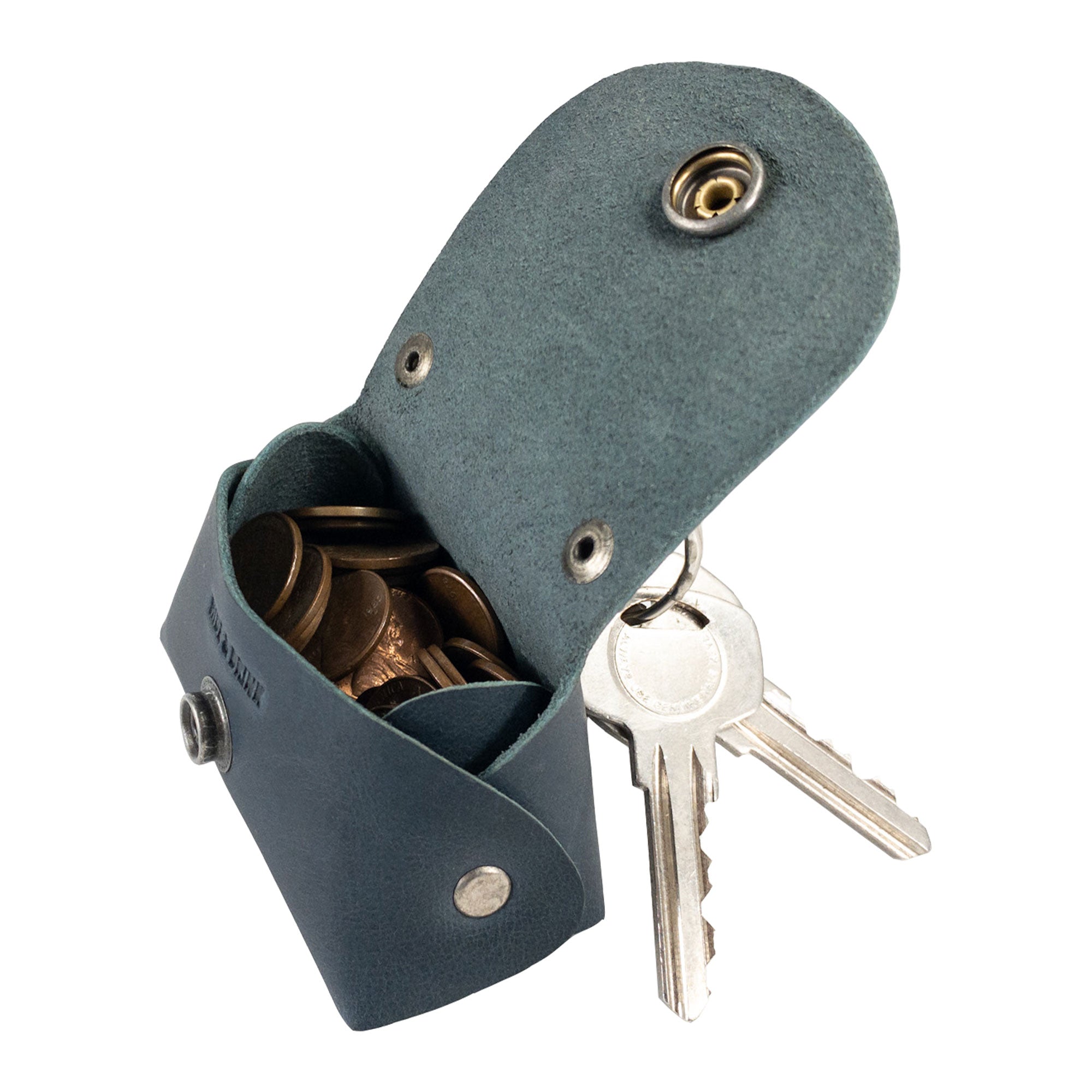 The Tiny Handbag Keychain by Hide & Drink opens to reveal its practical interior, crafted from Full Grain Leather and designed to hold coins and keys. This piece embodies handmade artistry and small batch production, perfect for those who appreciate unique accessories from StockyardX.