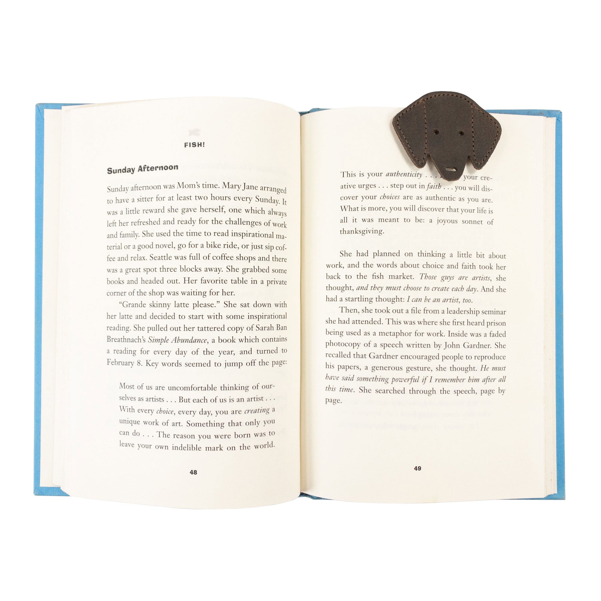 Hide & Drink's Dog Bookmark in use, slipped into a book page. This Full Grain Leather bookmark adds a rustic, handmade touch, showcasing small batch production techniques, artisan craftsmanship, and fire branded details from La Antigua Guatemala & Oaxaca Mexico.