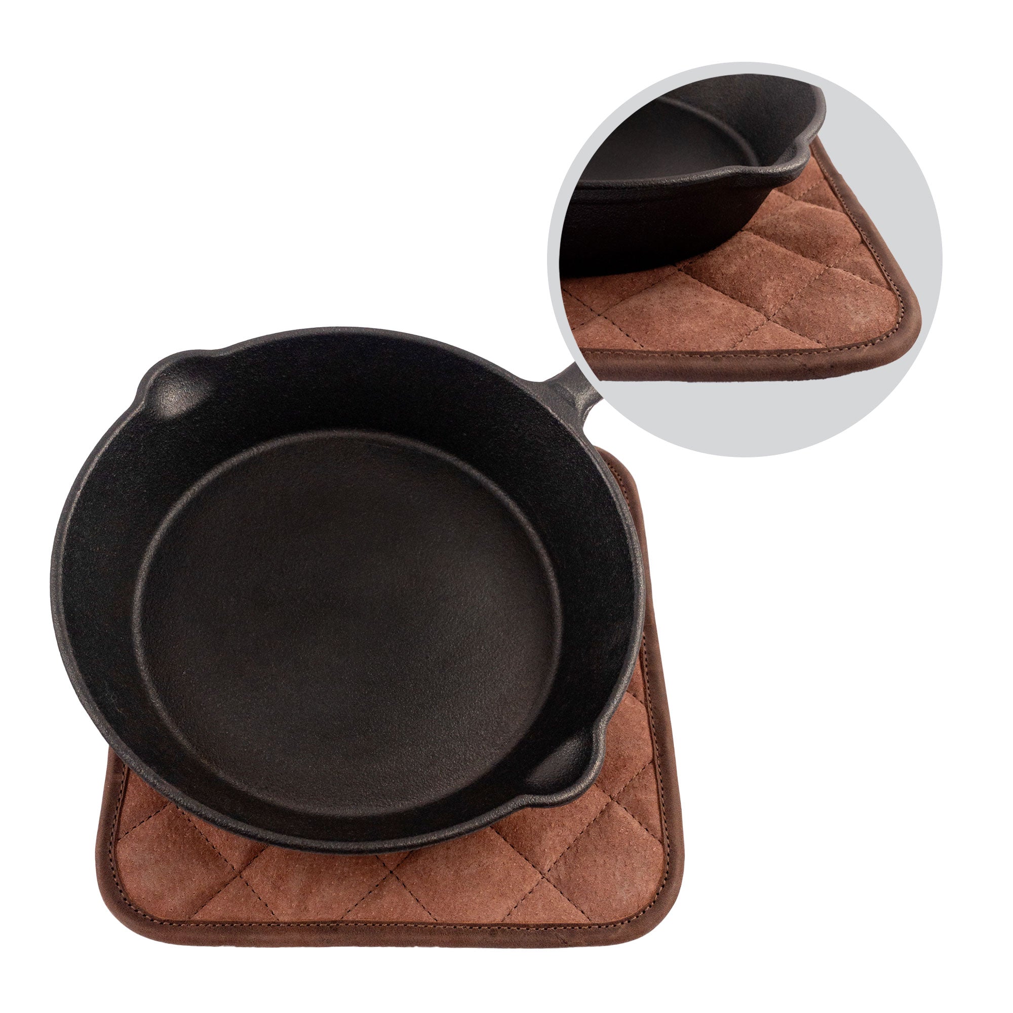 An overhead view of a cast iron skillet on the Cast Leather Co. Squared Hot Pot Pad, demonstrating its functionality and style. This Squared Oven Mitt Heat Resistant, Hot Pot Pad (Potholder) is a must-have for bakery supplies, constructed from full grain leather and sheepskin. It's part of stockyardX's small batch production, showcasing the artisanal craftsmanship from La Antigua Guatemala & Oaxaca Mexico.
