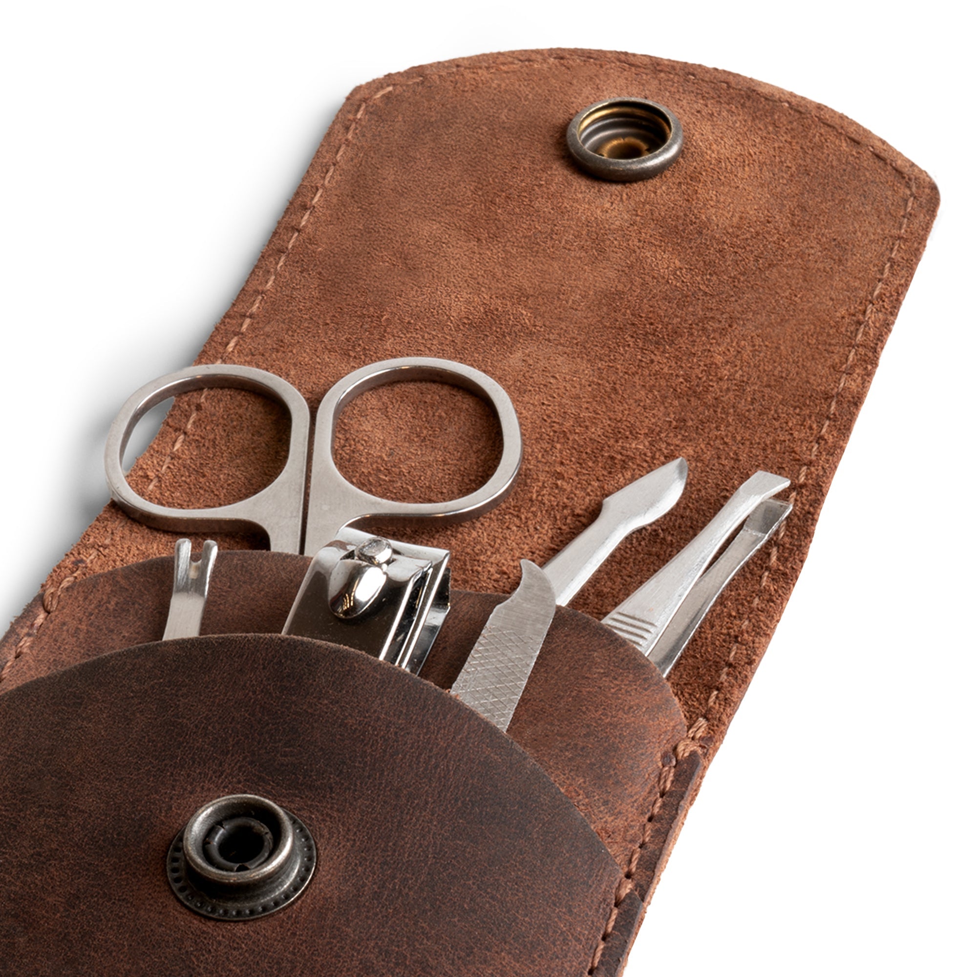 Close-up of Hide & Drink Nail Clipper Case with grooming tools visible, showcasing the use of high-quality full grain leather. Ideal as a travel accessory for nail care, this artisan product is hand cut, hand sewn, fire branded, and handmade in La Antigua Guatemala & Oaxaca Mexico.