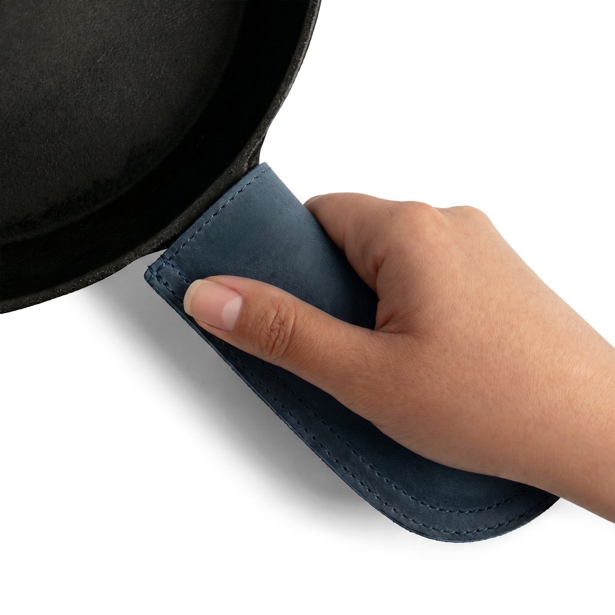Hide & Drink Cast Iron Panhandle Cover elegantly showcased on metal cookware. This durable hot handle protector is crafted from full grain leather and features artisan double stitching. Handmade in La Antigua Guatemala & Oaxaca Mexico, it provides both comfort and safety during cooking.
