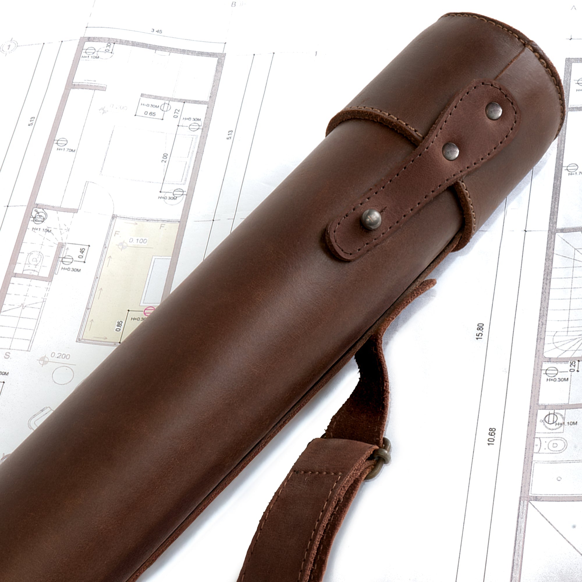 Close-up of Hide & Drink's Blueprint Tube (A2 Paper Size), highlighting the leather craftsmanship and snap button closure. This artisan-made document storage tube, featuring an adjustable strap, is perfect for architects and designers. Proudly made from full grain leather in La Antigua Guatemala & Oaxaca Mexico, showcasing StockyardX's handmade ethos.