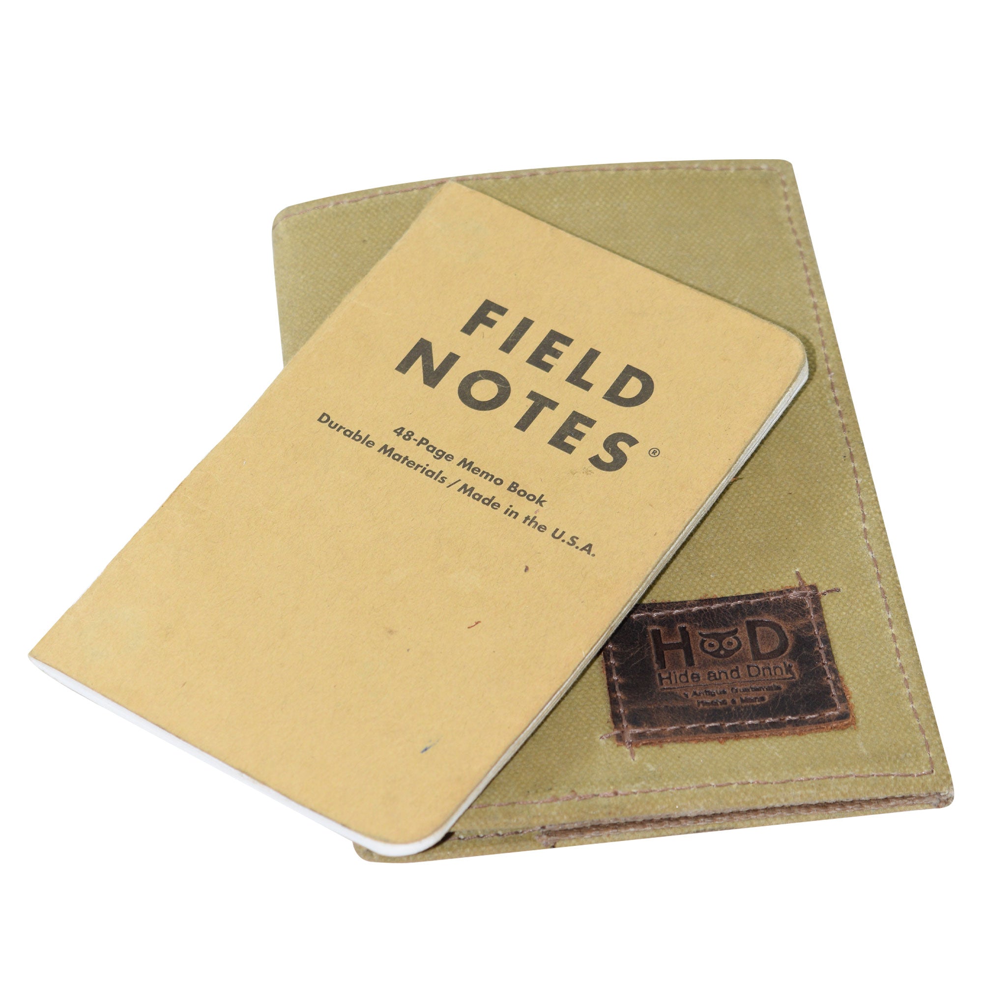 Hide & Drink Waxed Canvas Field Notes Cover with a Field Notes notebook beside it, illustrating the perfect pairing for everyday writers. This practical Waxed Canvas Field Notes Cover serves as a Wallet Case (3.5 x 5.5 in.) Journal Cover, elegantly designed for travelers.