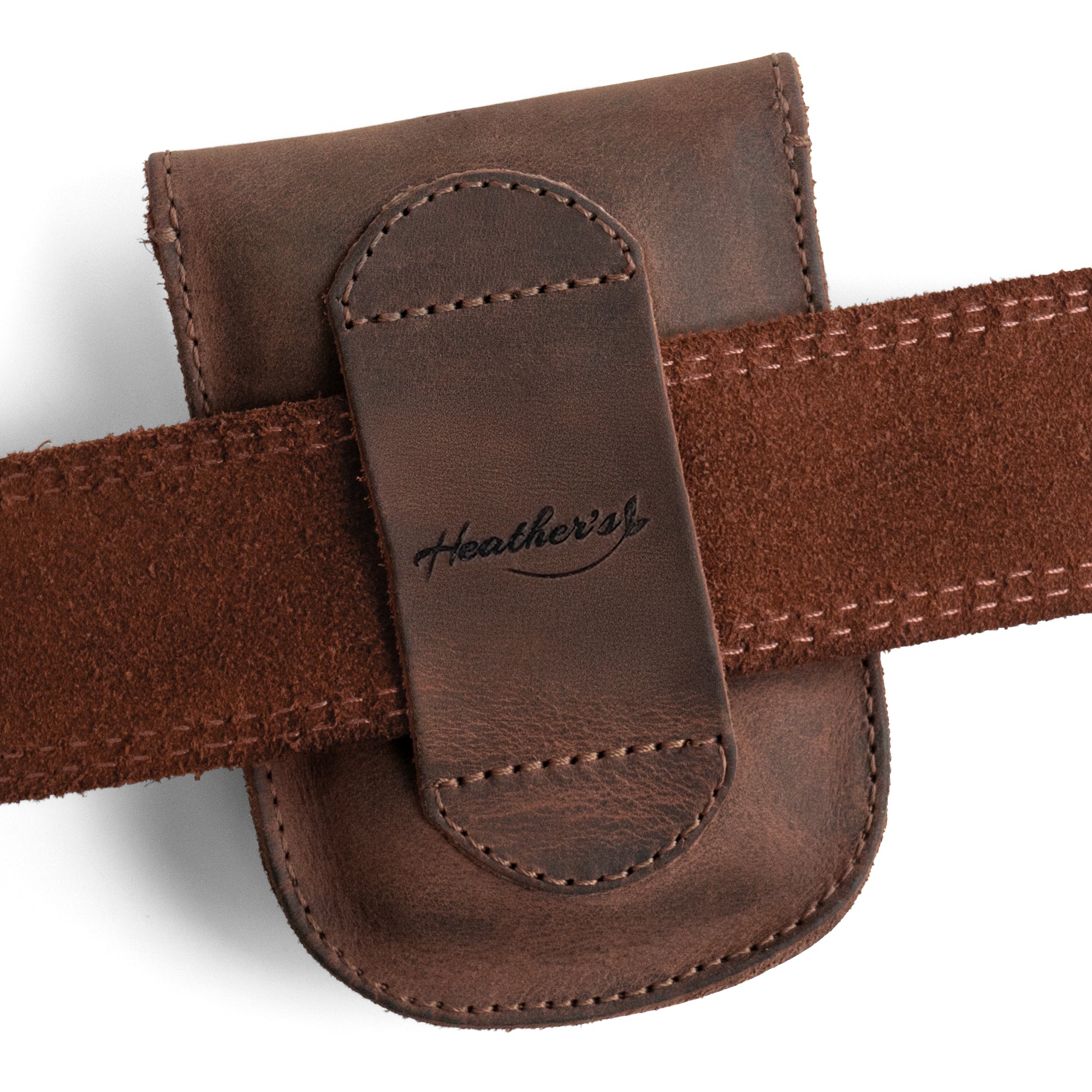 Close-up of the logo on the back of the Curvy Waist Bag by Heather's, highlighting its artisanal craftsmanship. This durable waist bag, styled as a holster pouch, is perfect for carrying coins, change, headphones, and personal items. Designed for convenient attachment to a belt, it's produced from fine full grain leather. Each bag represents small batch production, hand cut, hand sewn, and is fire branded, crafted in La Antigua Guatemala & Oaxaca Mexico.