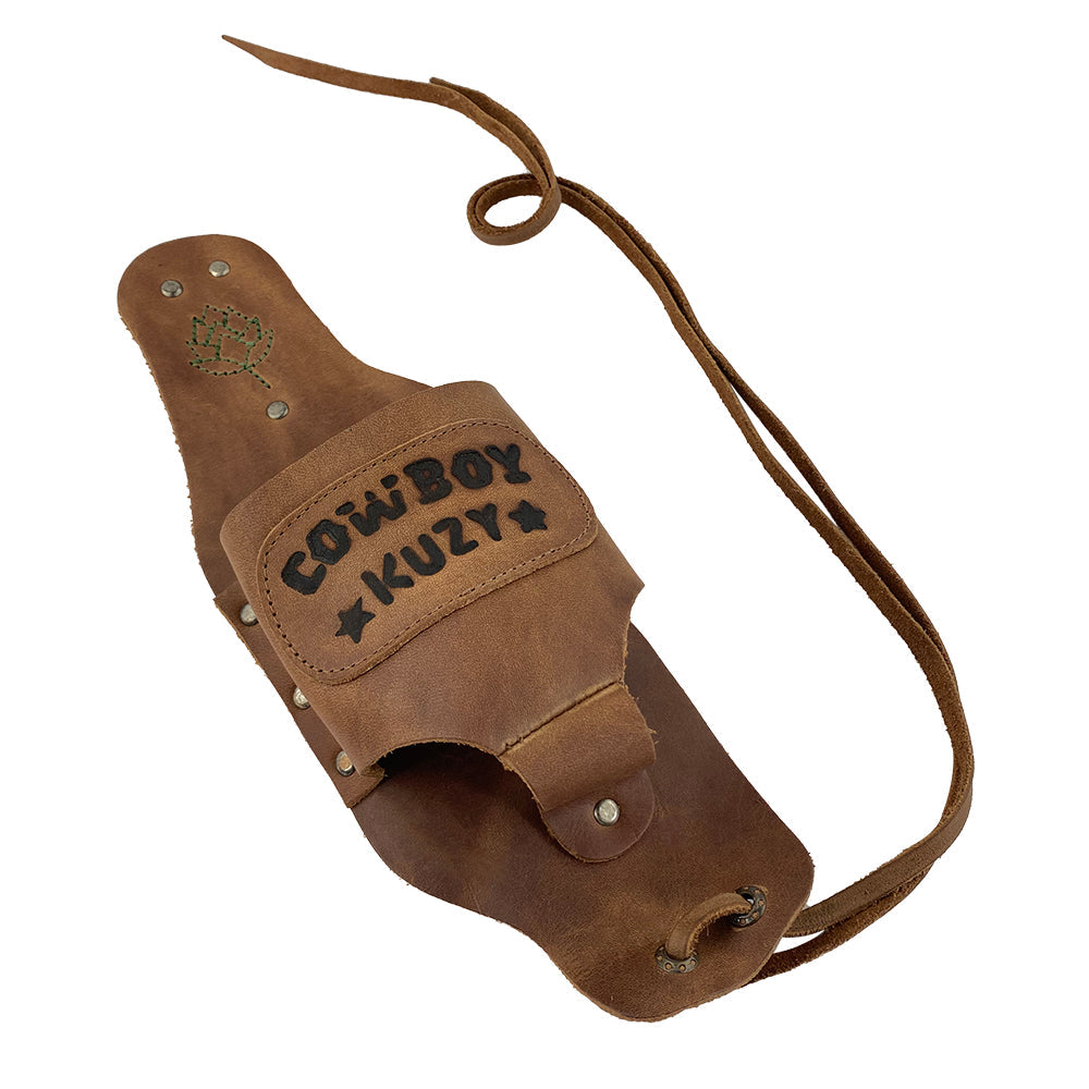 Side view of the Beer Holster Stitched Designs by Hide & Drink with intricate 'COWBOY KUZY' stitching and a secure leather tie. This handsfree beverage holder is perfect for men and women, exemplifying quality Full Grain Leather construction as a Beer Holster for Cowboy. Crafted using small batch production techniques, hand cut and hand sewn for durability, and fire branded artisan work from La Antigua Guatemala & Oaxaca Mexico.