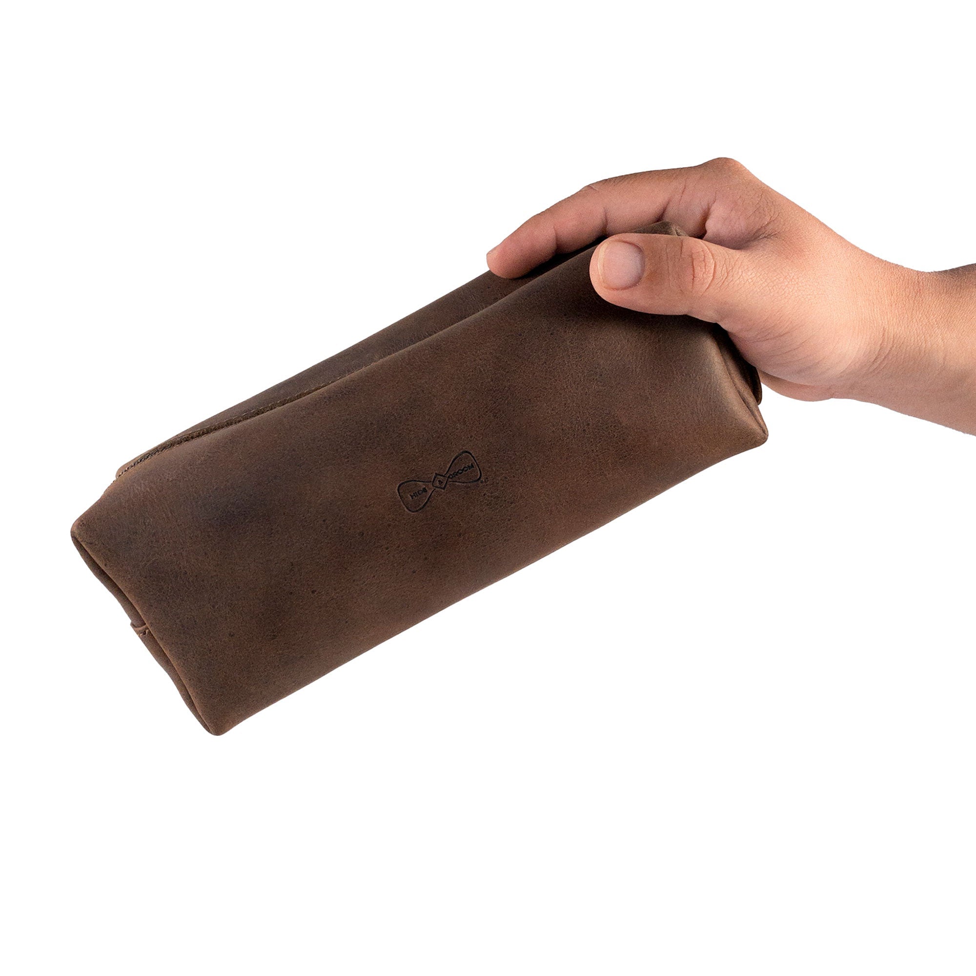 Rectangular Toiletry Bag for Groomsmen by Hide & Groom, being held in one hand to showcase its portable design. This full grain leather bag is perfect for best men, bachelors, and anyone attending wedding ceremonies, offering stylish shaving kit storage.