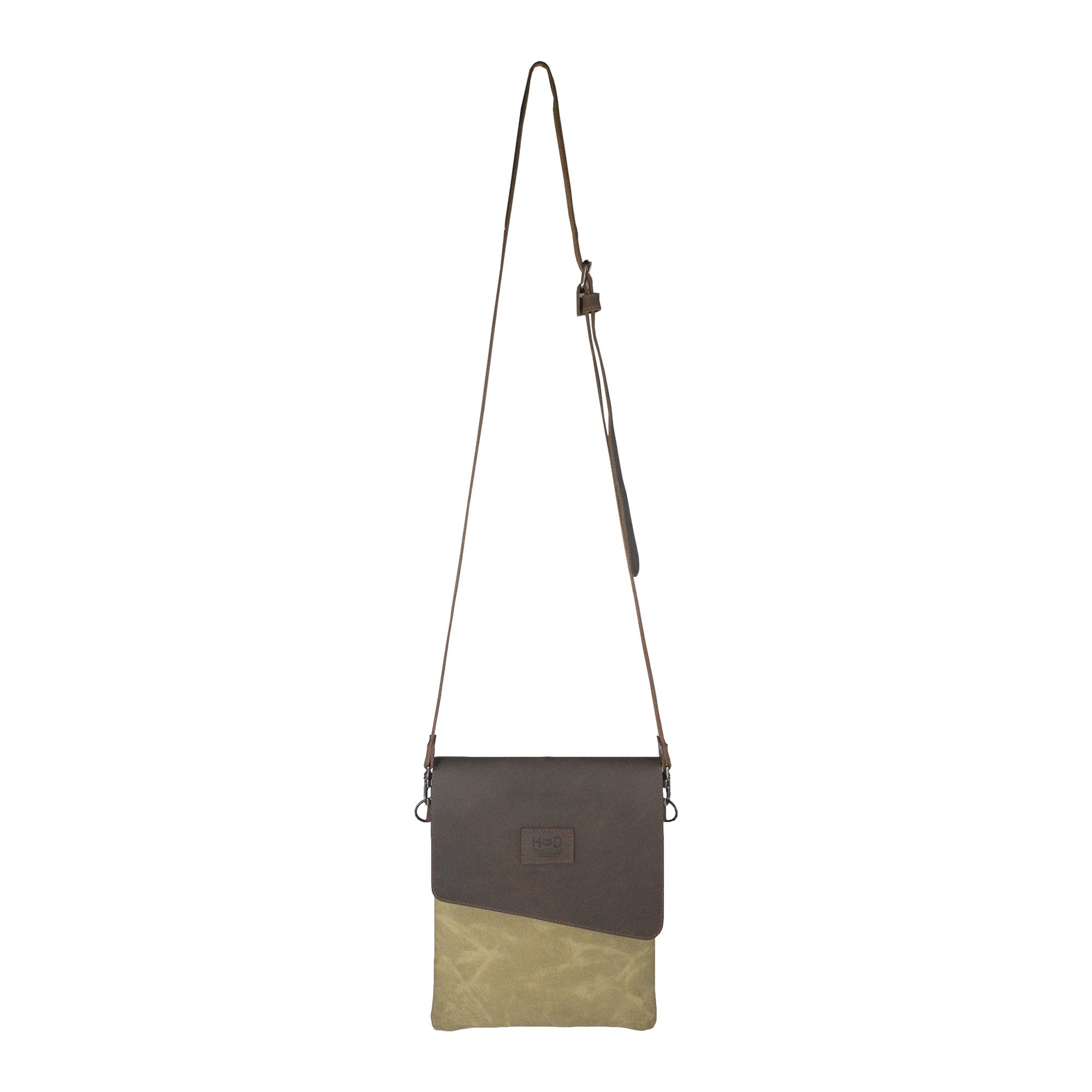 Hide & Drink Crossbody Bag displayed against a white background, highlighting its stylish two-tone design. This Crossbody Bag with Adjustable Shoulder Strap is a Unisex Messenger Bag crafted from Full Grain Leather & Waxed Canvas, representing small batch production, hand cut, hand sewn, fire branded quality, handmade by artisans in La Antigua Guatemala & Oaxaca Mexico.