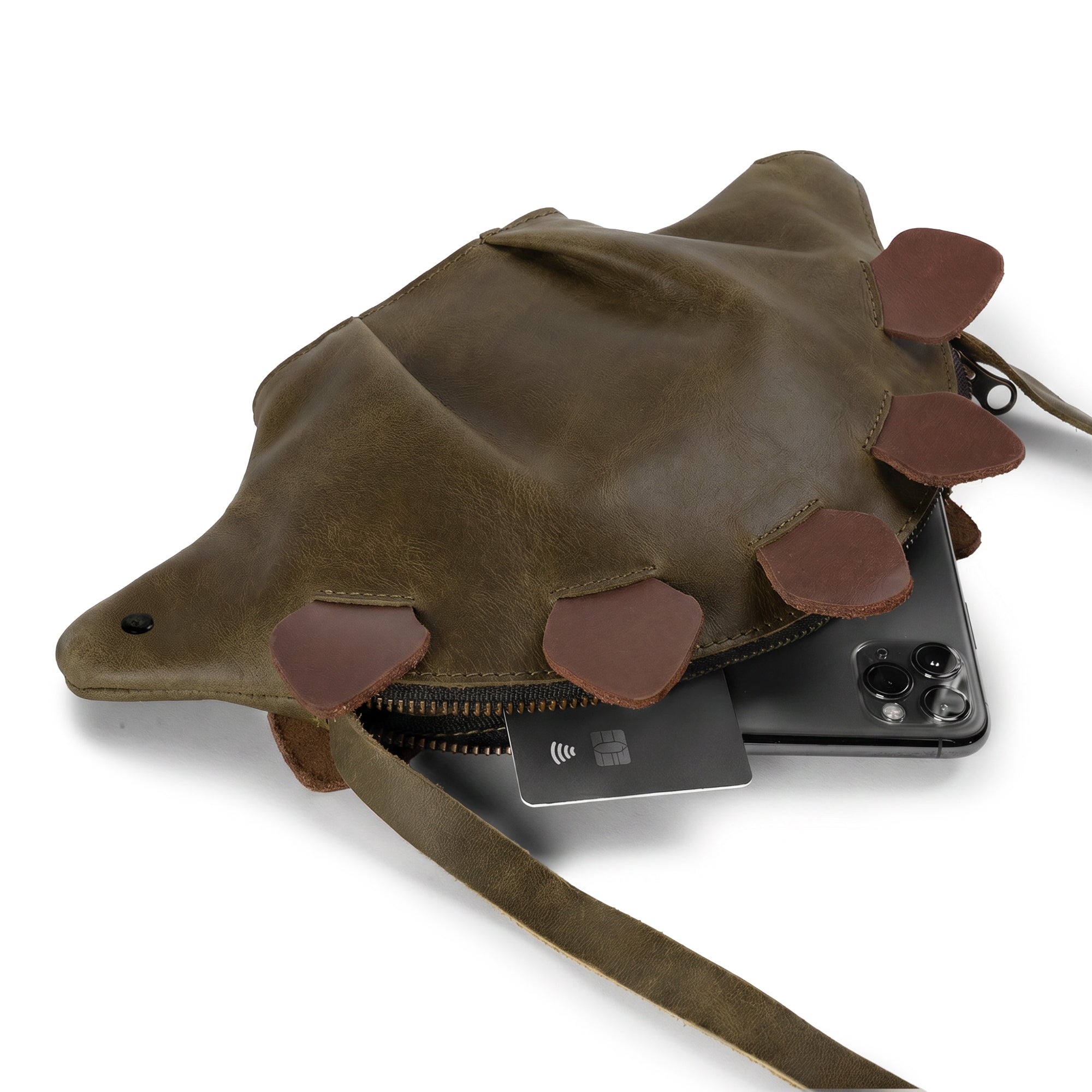 Dinosaur-Shaped (Stegosaurus) Shoulder Bag by Tudi Frudi displaying its capacity with essentials inside, highlighting its versatility as a Crossbody Bag made from Full Grain Leather. Perfect for daily use, this Artisan piece is Hand Cut, Hand Sewn, and Fire Branded.