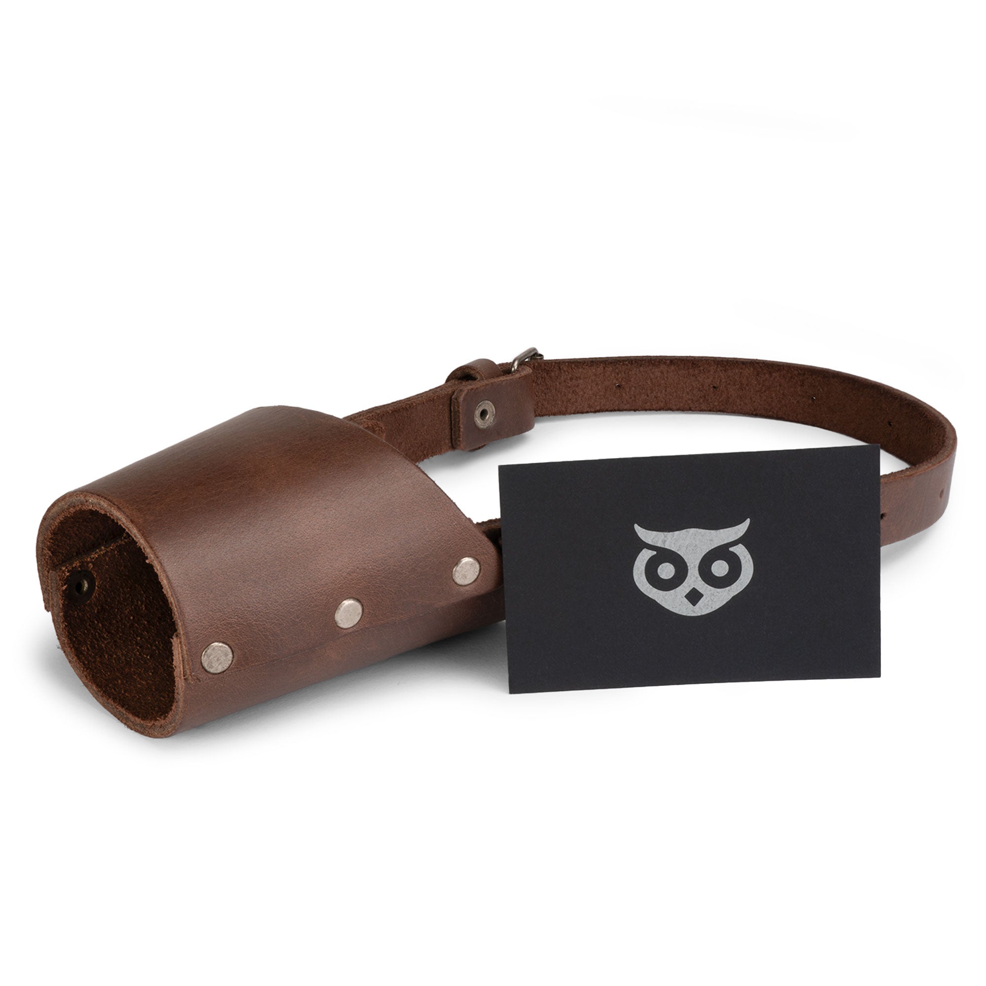 Riveted Dog Muzzle by Hide & Drink displayed with branded card, emphasizing its high-quality craftsmanship and secure design. This full grain leather dog muzzle guard is designed to prevent biting and chewing, making it suitable for breeds like Pitbulls and German Shepherds, handmade in La Antigua Guatemala & Oaxaca Mexico.