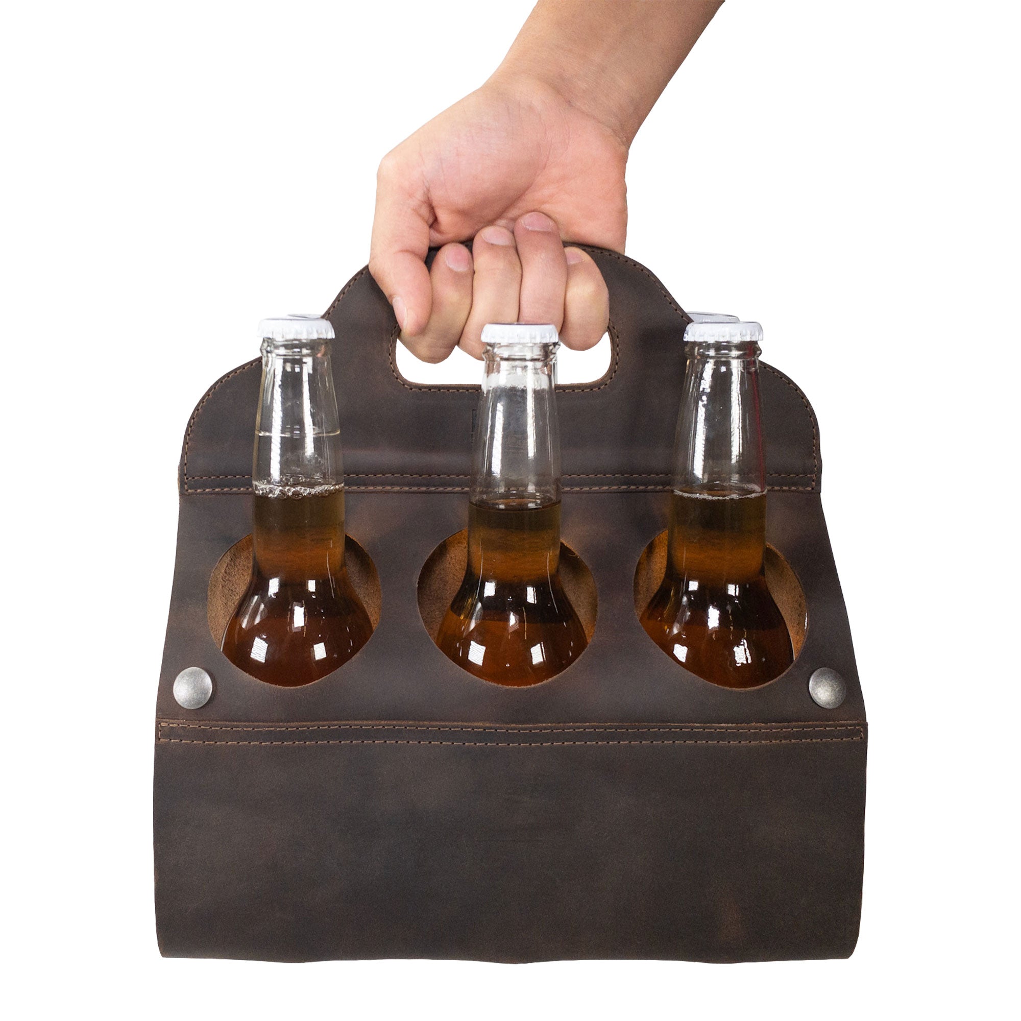 Person holding Hide & Drink's Six Bottle Caddy with three beers inside, designed as a practical Beer Holster for Bike. This Full Grain Leather product exemplifies Small Batch Production and is beautifully hand cut and hand sewn by expert artisans.