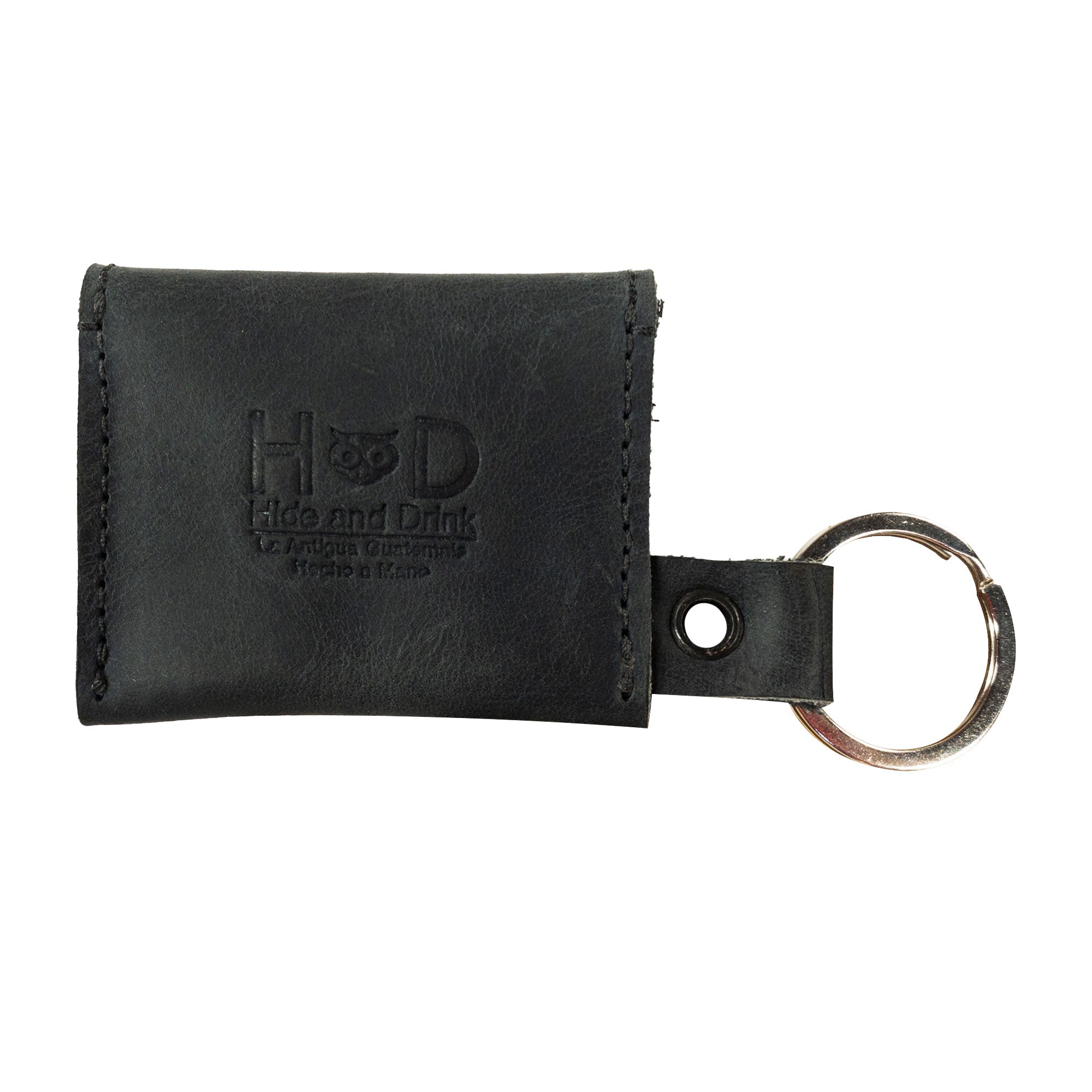 Another view of the Tiny Coin Holder Keychain by Hide & Drink showing its branding and sleek Full Grain Leather finish. This Tiny Coin Holder, handmade in small batches, reflects dedication to craftsmanship and functional design.