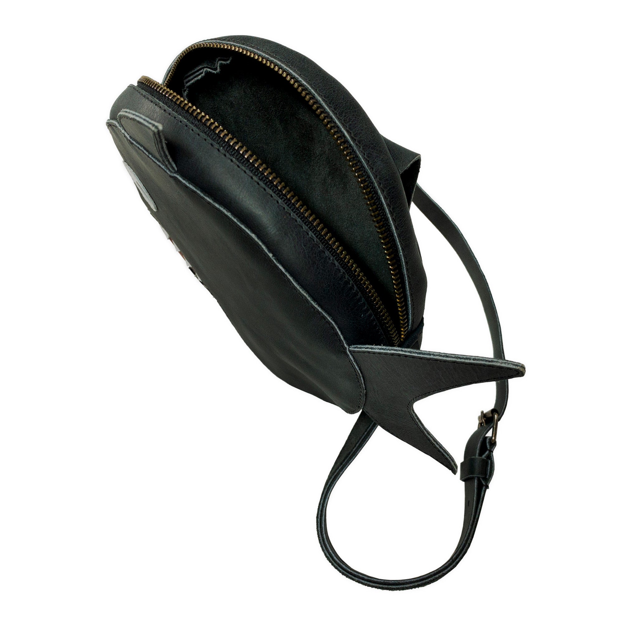 An overhead view of Tudi Frudi's Piranha-Shaped Shoulder Bag reveals its spacious interior and meticulously crafted details. This Piranha-Shaped Circular Shoulder Bag showcases the beauty of Full Grain Leather and emphasizes the brand’s commitment to traditional artisan techniques with each hand cut and hand sewn element.